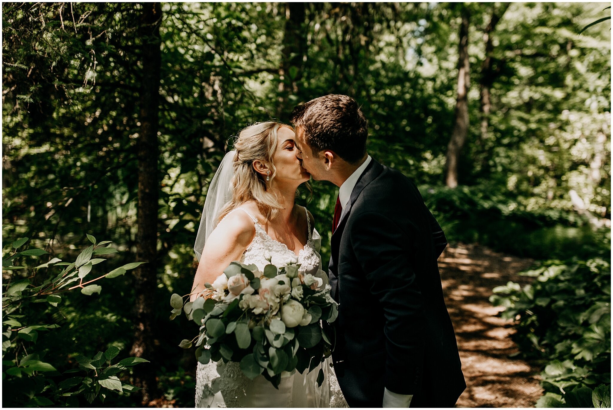 bride and groom kiss in van dusen gardens wedding