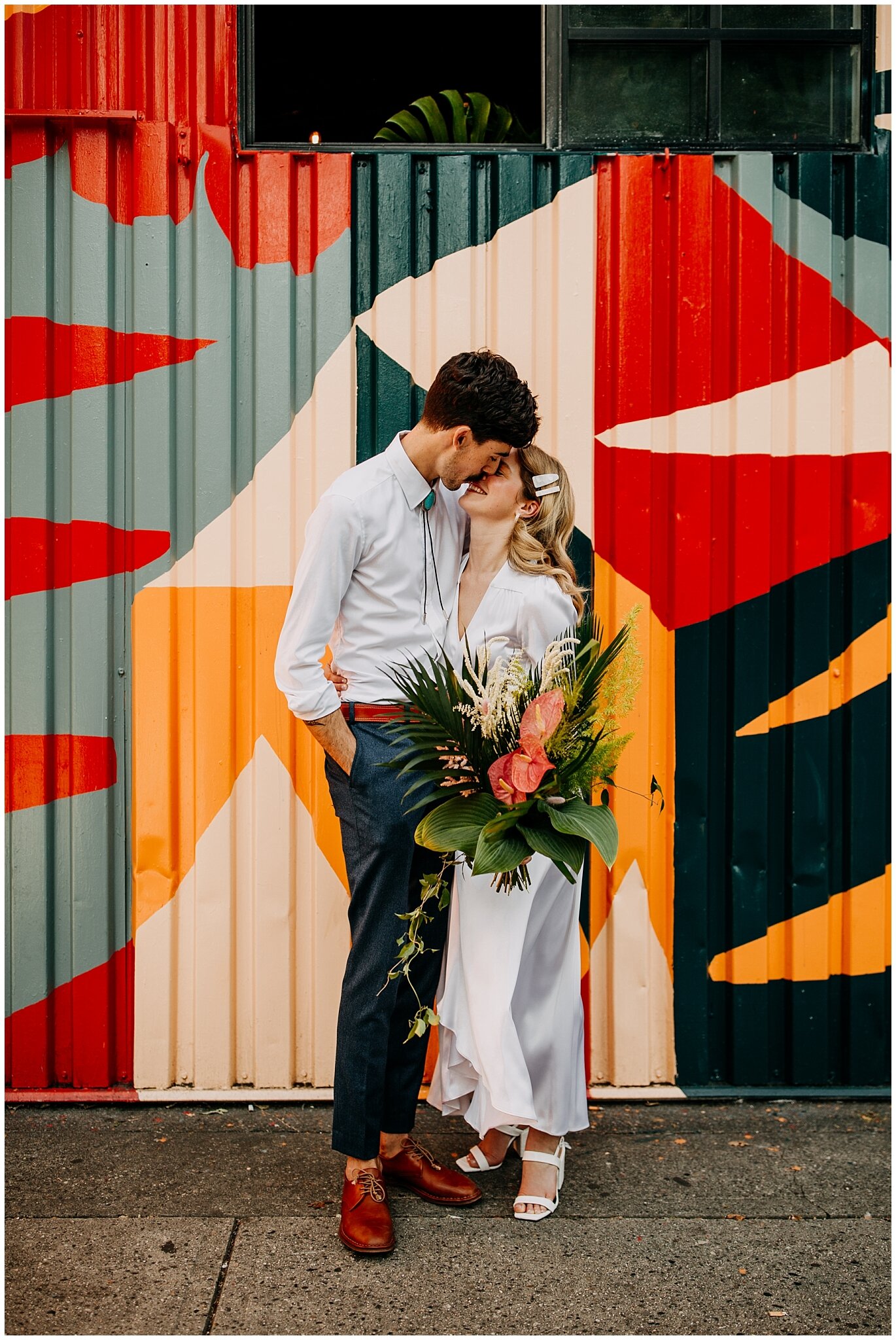 bride and groom portrait in front of mural at ellis building wedding