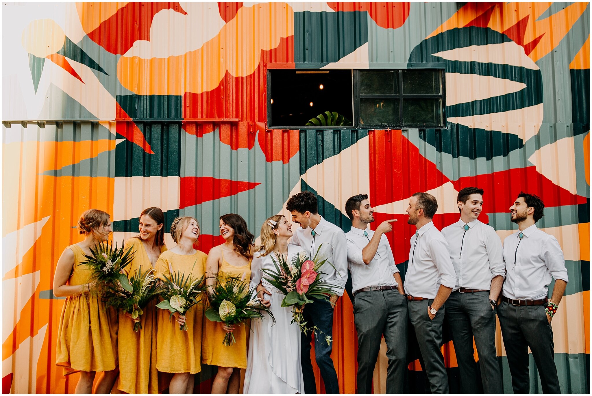 wedding party portrait in front of mural at ellis building wedding