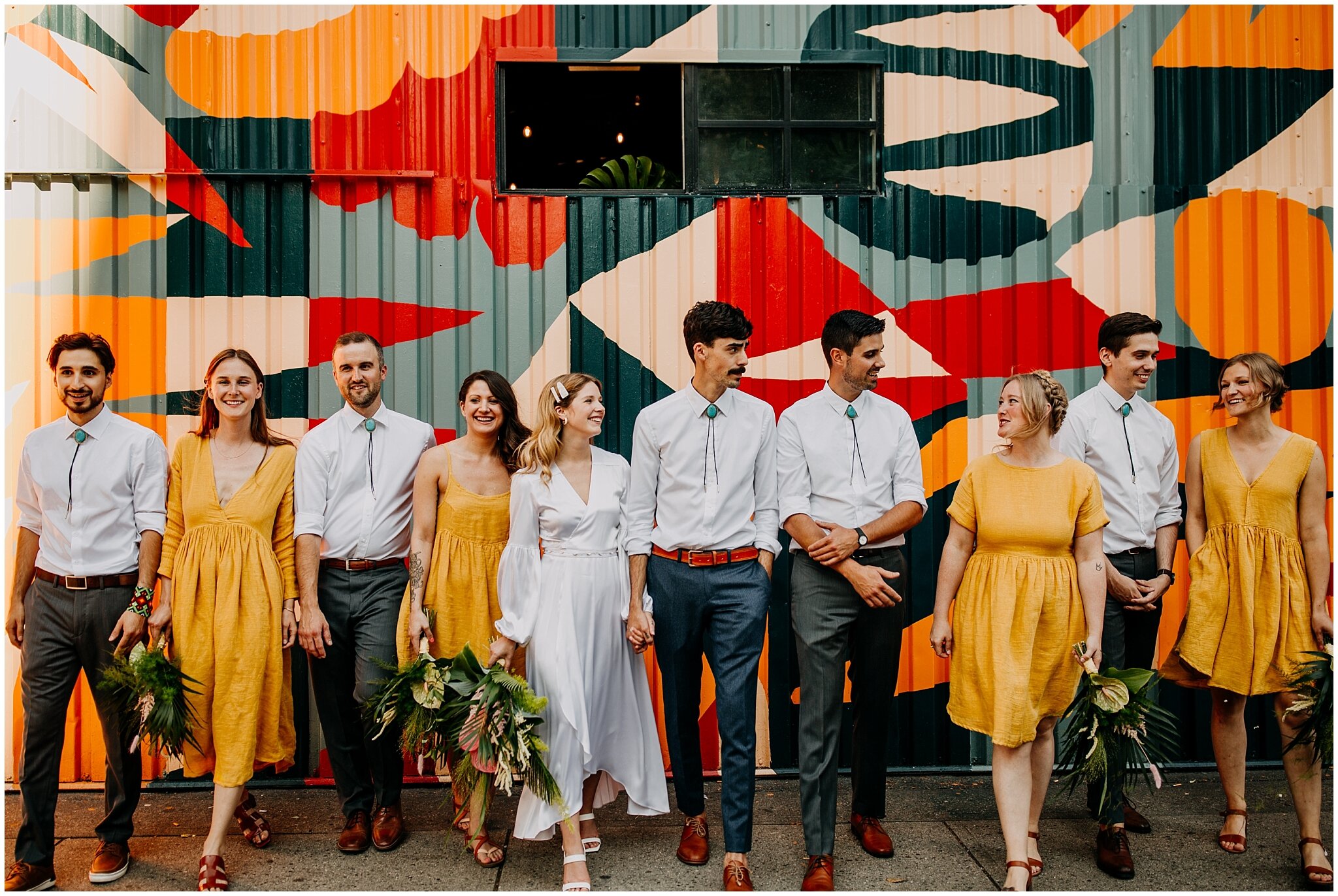 wedding party portrait in front of mural at ellis building wedding
