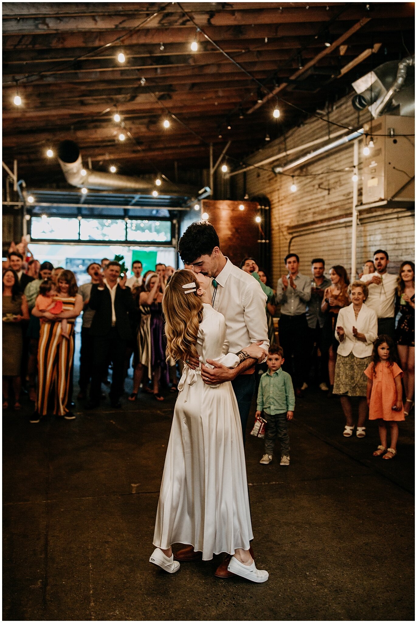 bride and groom kiss during first dance at ellis building wedding