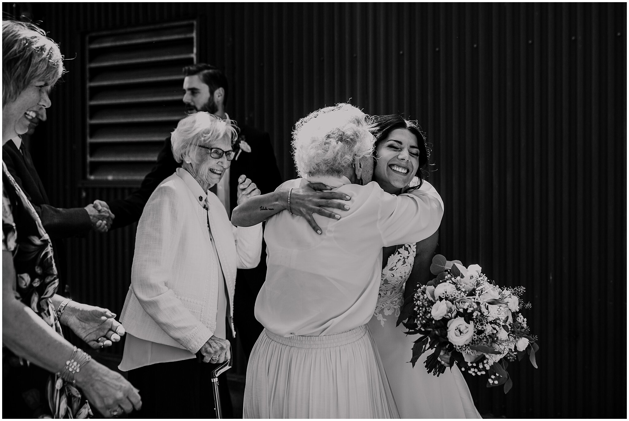 bride and grandma hugging candid moment at granville island wedding