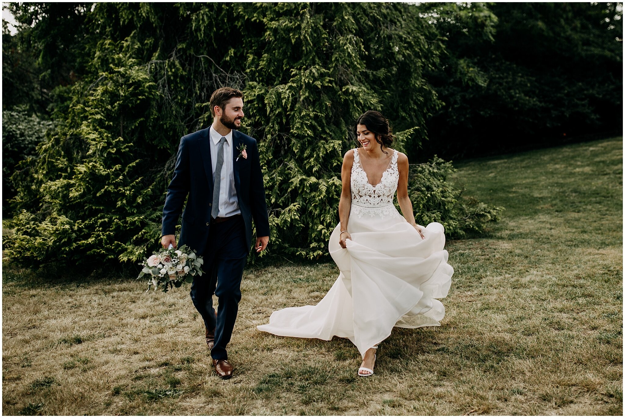 bride and groom walking through field at queen elizabeth park