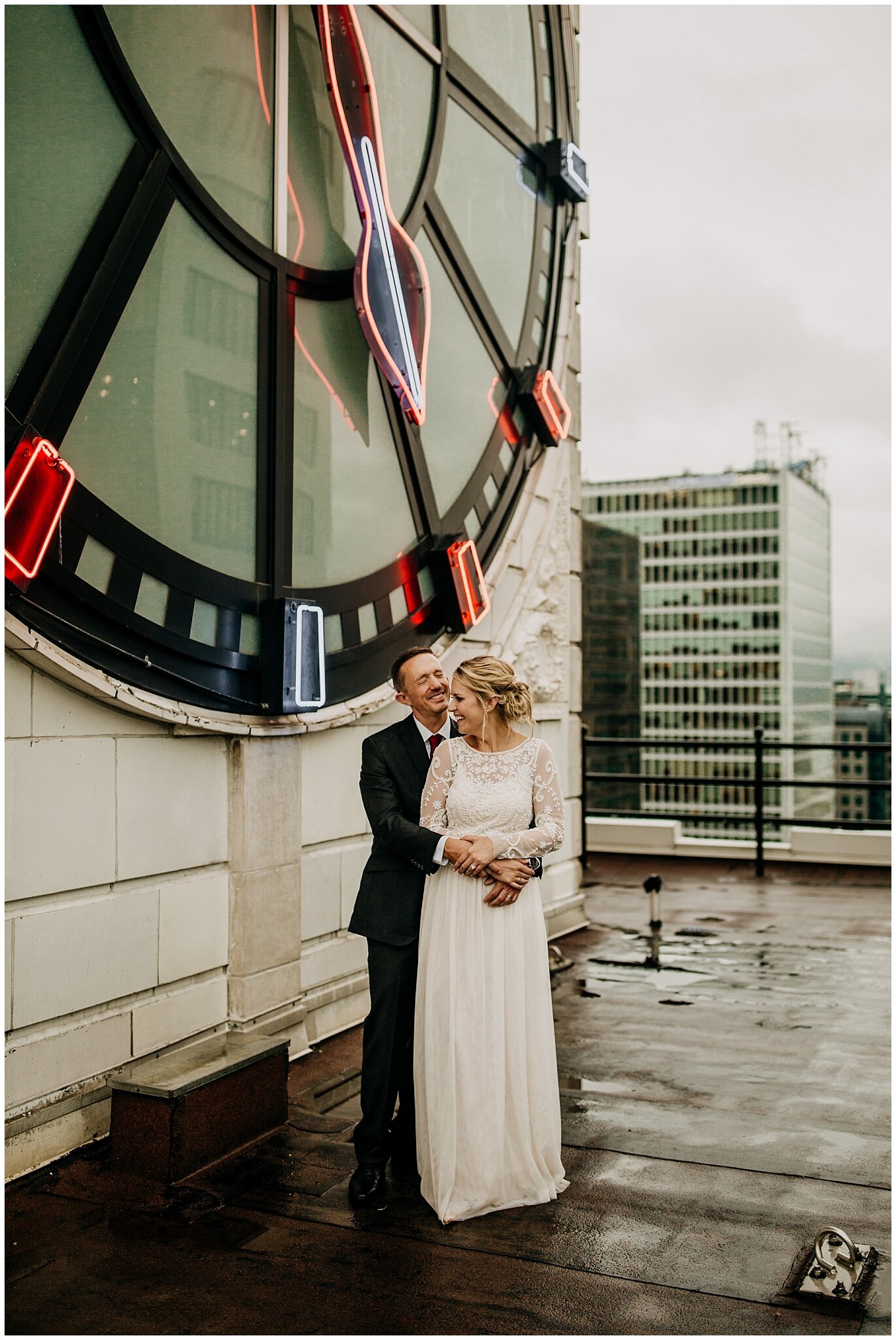 bride and groom portrait in front of clock in vancouver block building