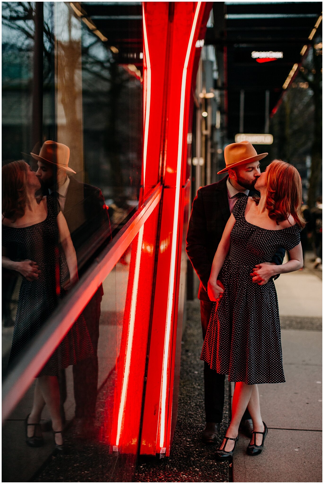 couple in front of red neon sign in vancouver for engagement session