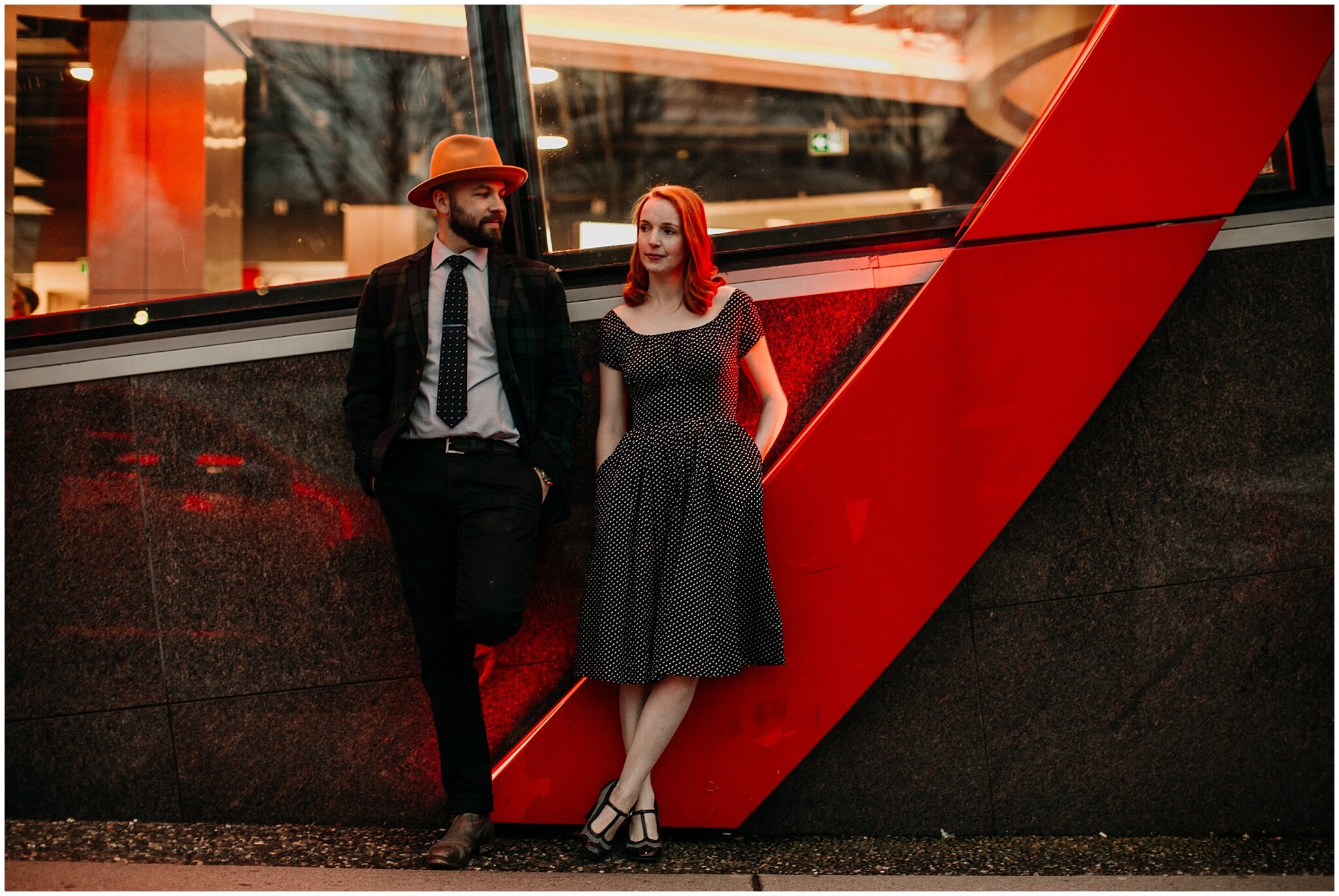 hip couple in front of red neon sign in downtown vancouver
