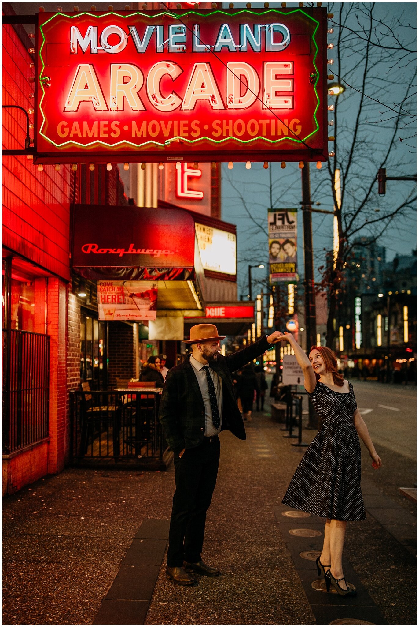 couple dancing in engagement photos with neon lights in vancouver