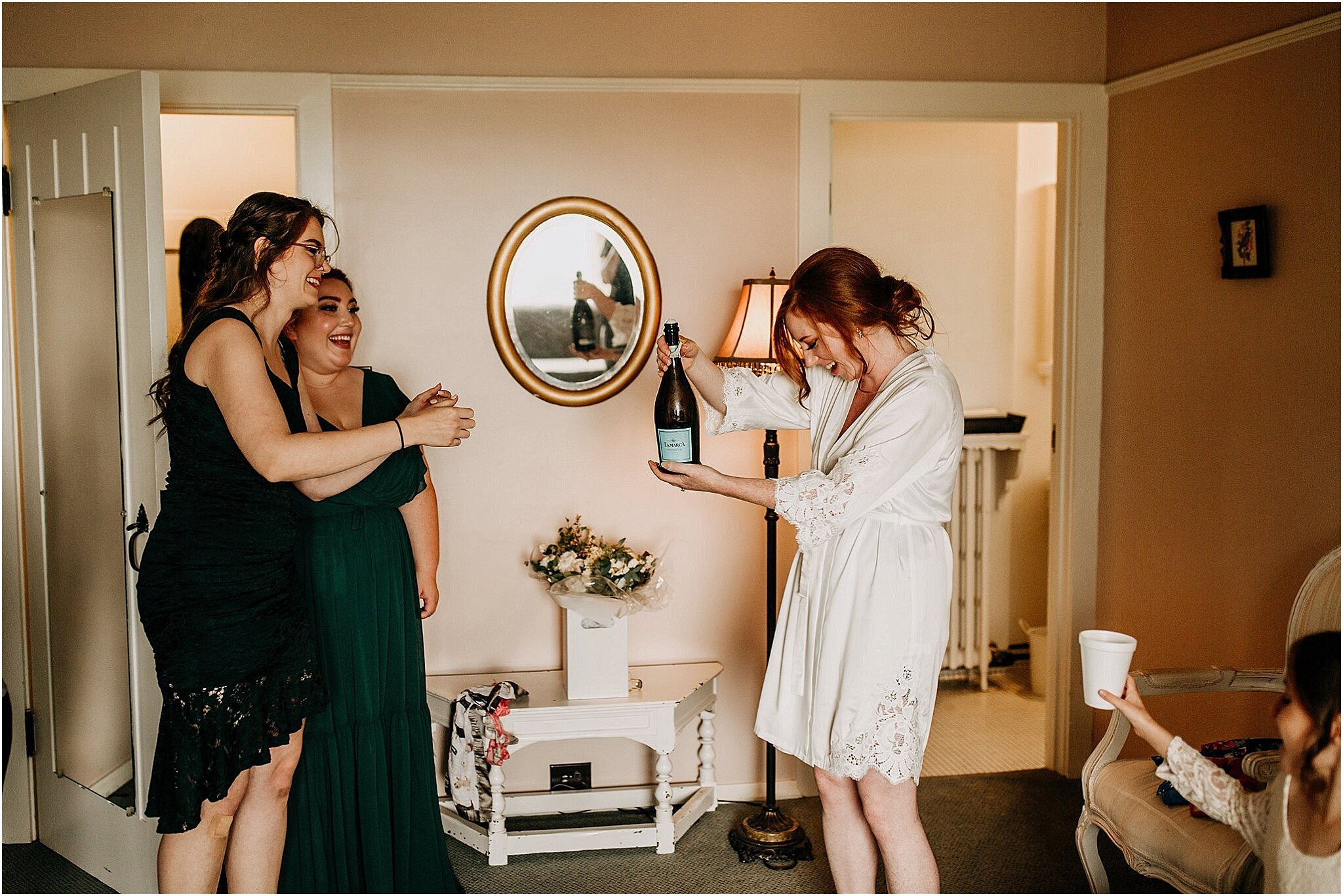 bride popping champagne with bridesmaids Minnekhada Lodge Port Coquitlam BC