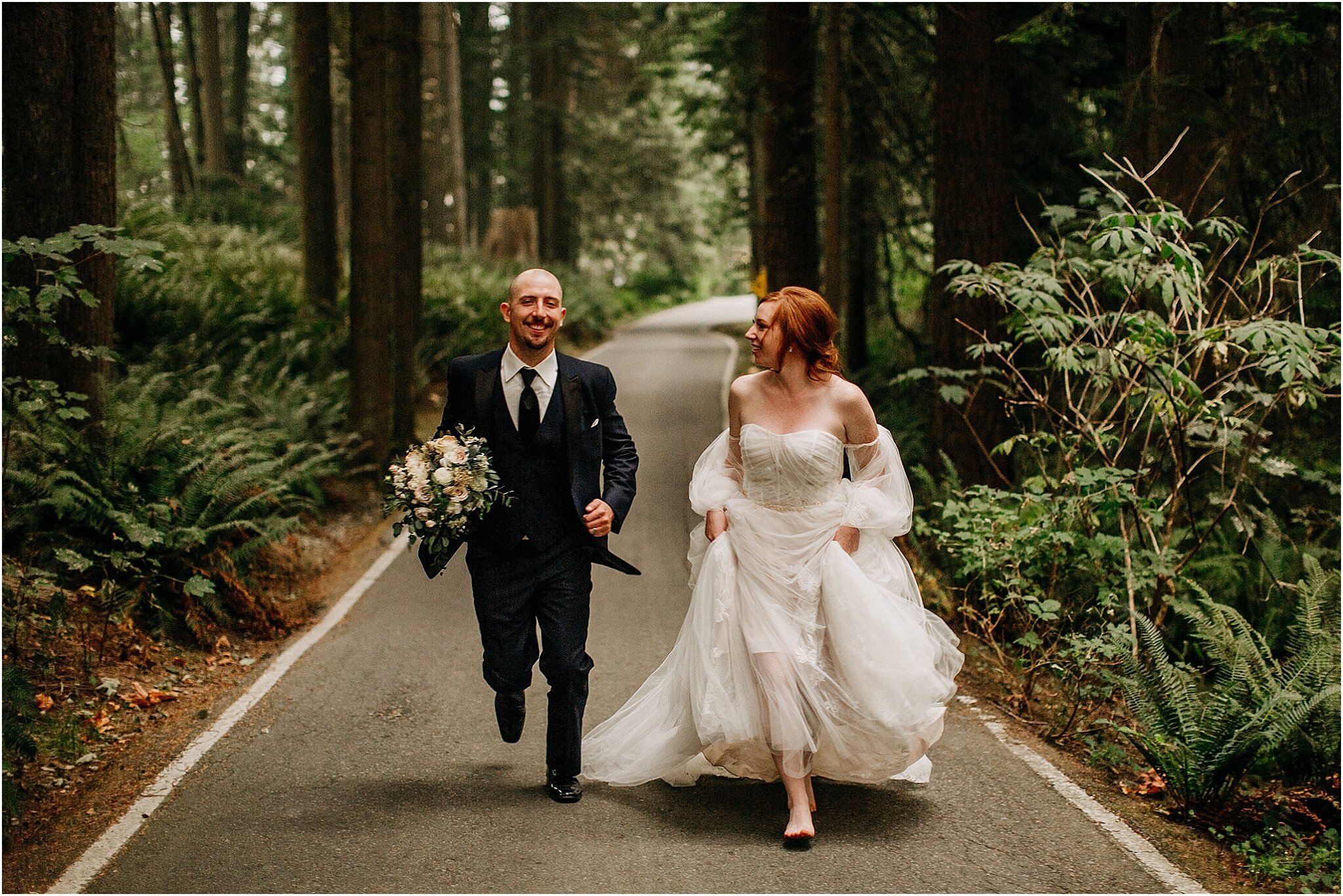 bride and groom running through forest Minnekhada park Port Coquitlam BC