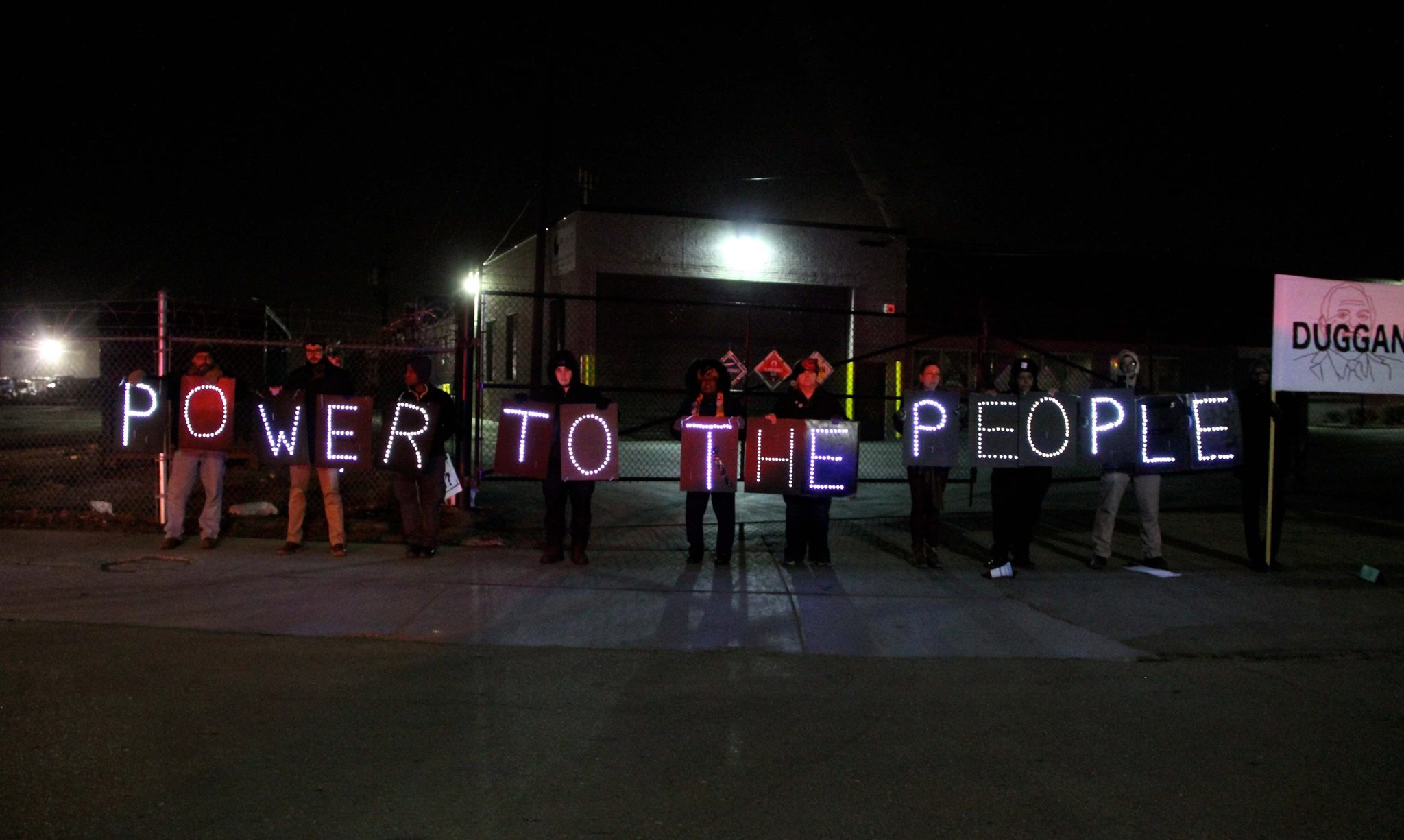 Detroit Light Brigade with “Power to the People” signs outside the State of the City address. Photo Credit: Shanna Merola
