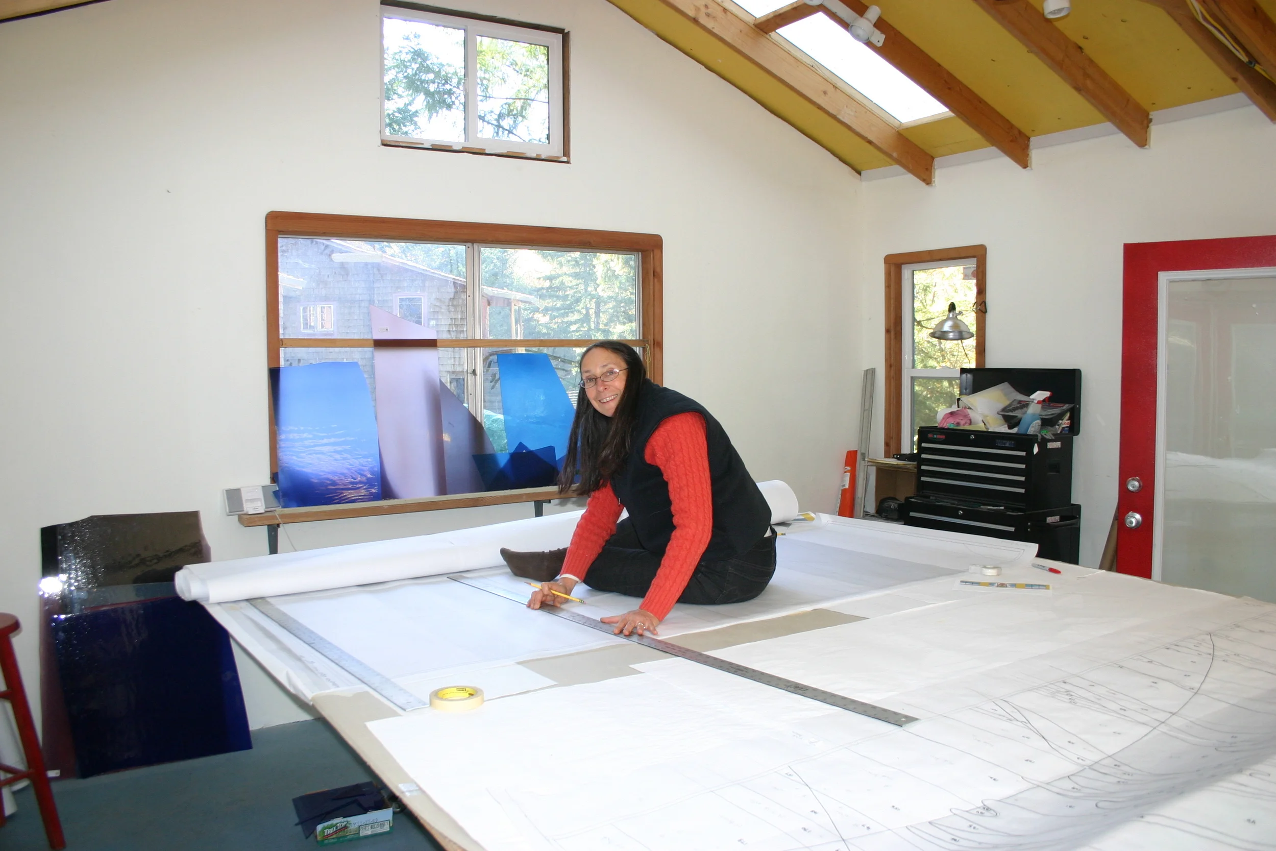  Michelle climbs up onto the table in order to work on the cartoon for a large panel. 
