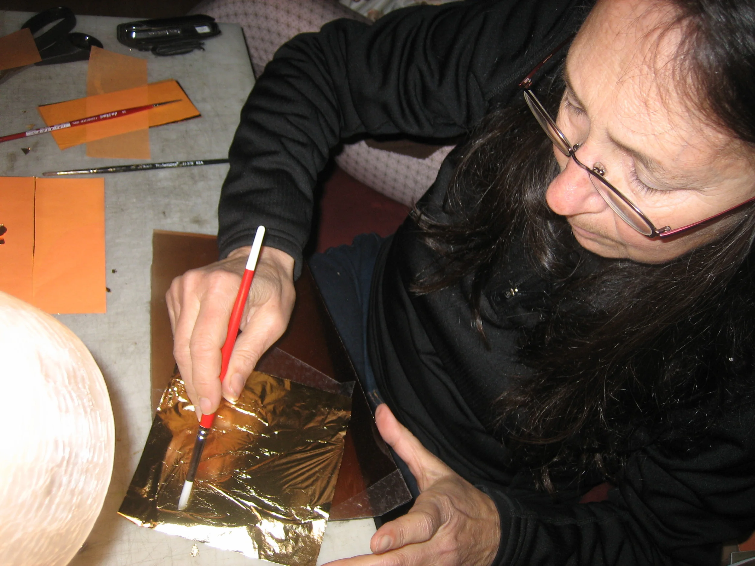  The gold leaf being burnished onto the glass. 