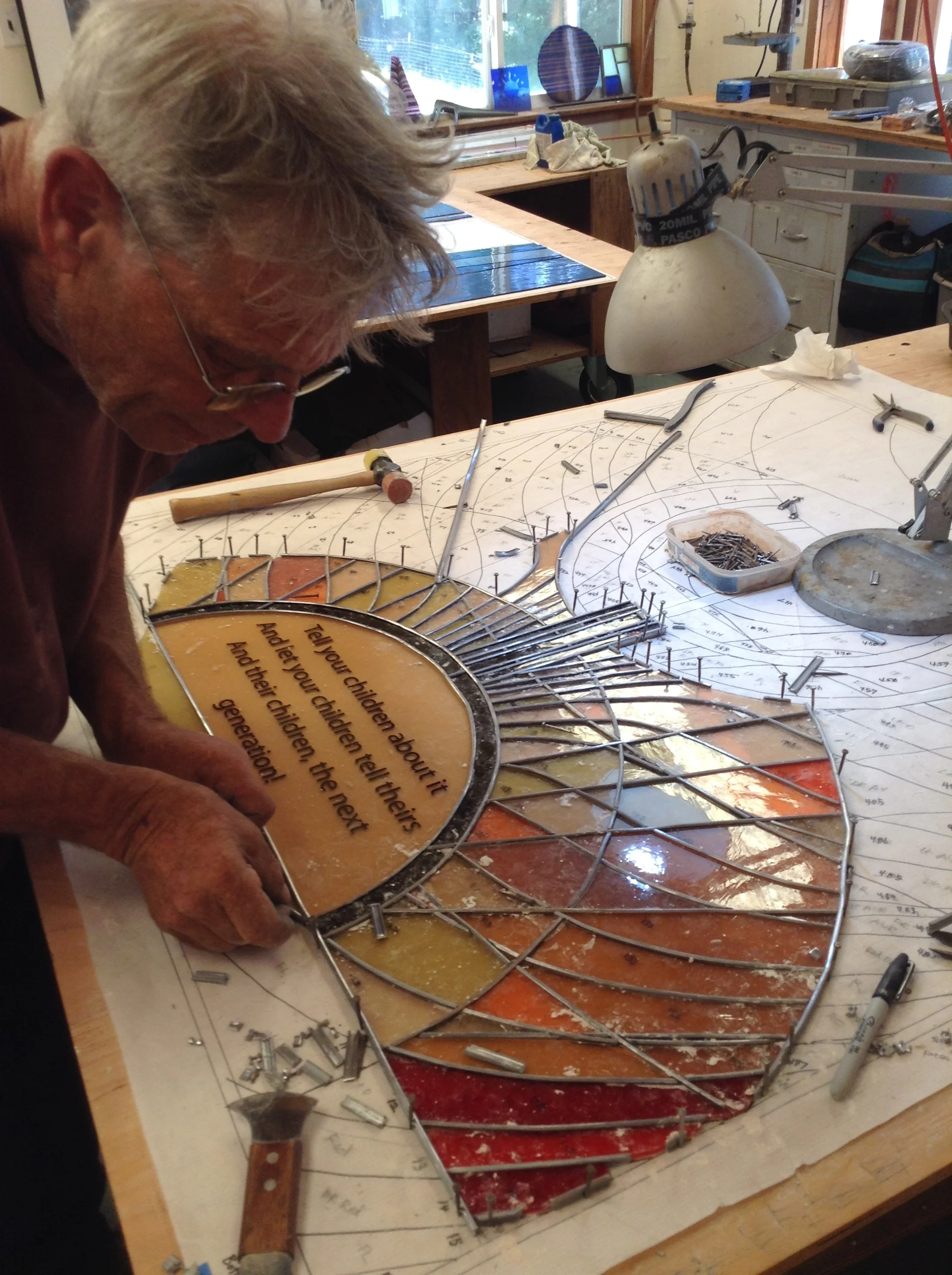 David carefully measures the length for a piece of lead channel during the assembly of the Holocaust Memorial panel.