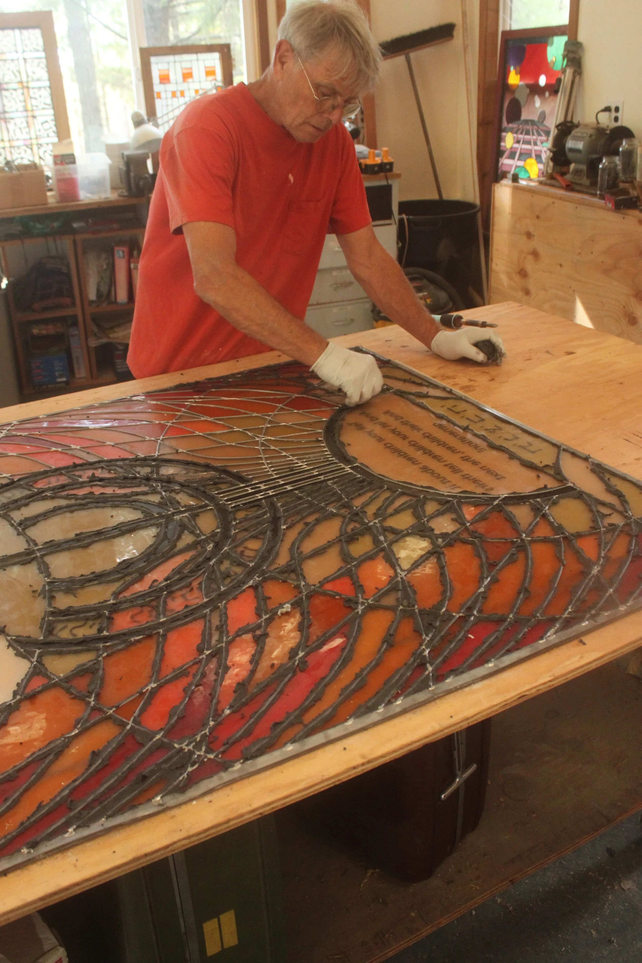 David putties the window after it has been soldered and steel-wooled.