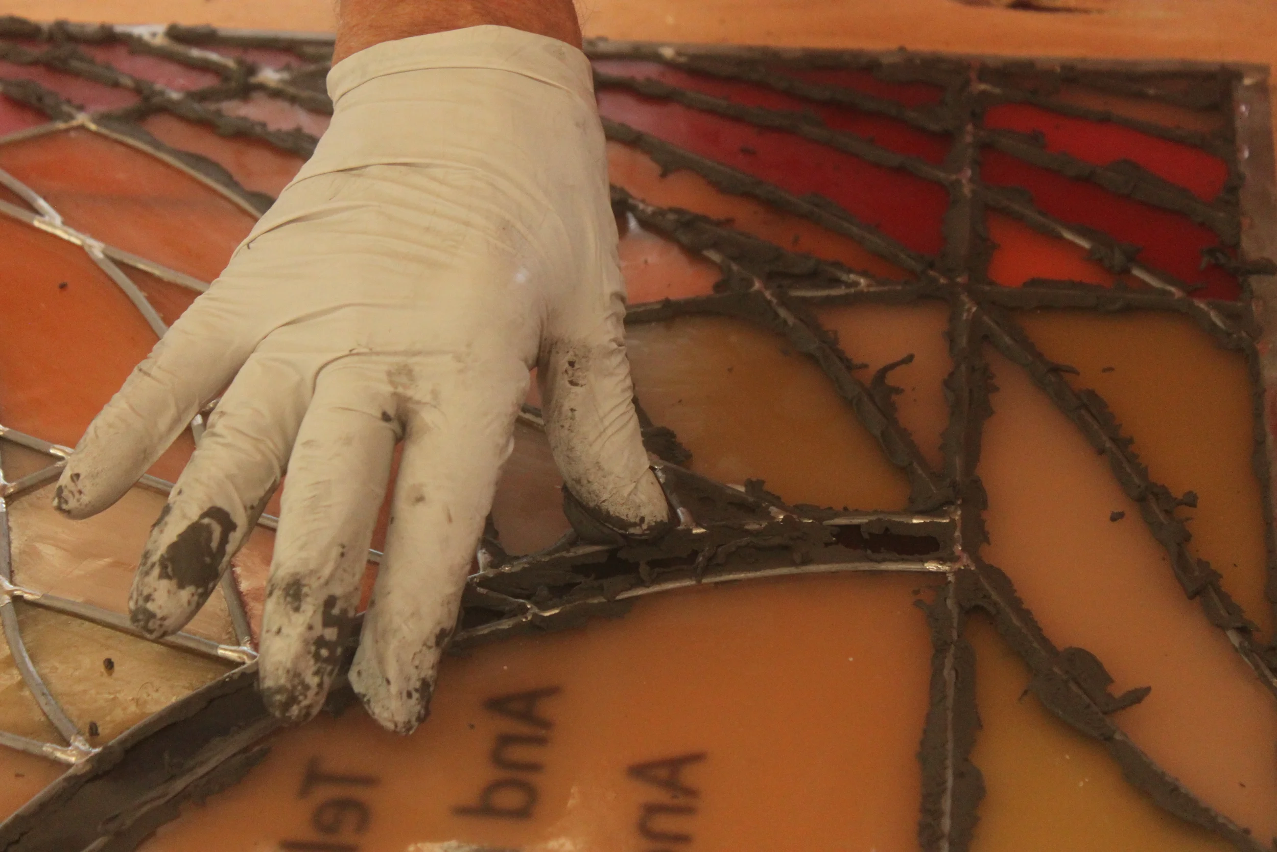 Special glazing putty is pushed under the channel around each piece of the window, in order to fill and spaces in the lead and make the panel rigid. 