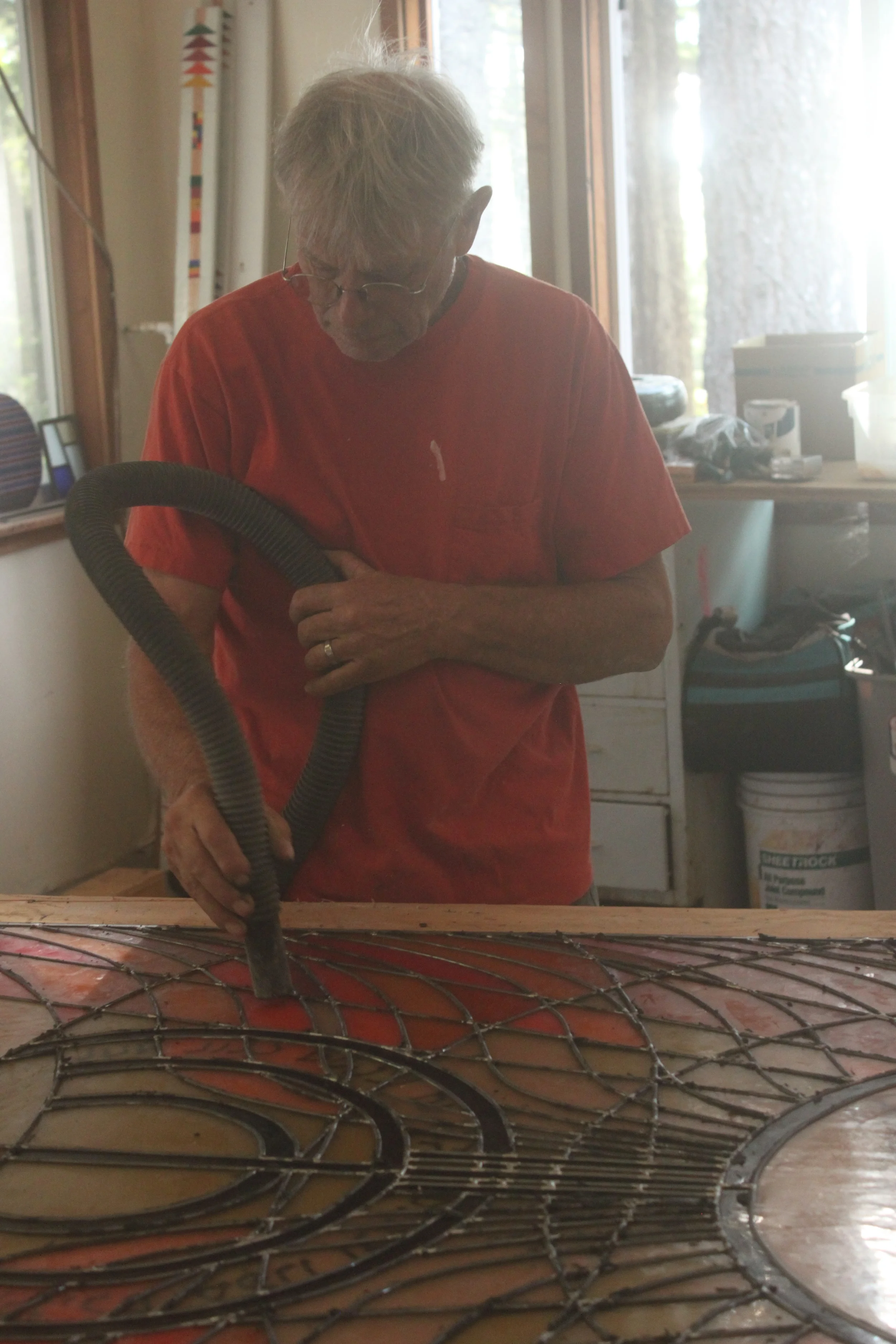 David uses the vacuum cleaner several times in the process of cleaning up after puttying.