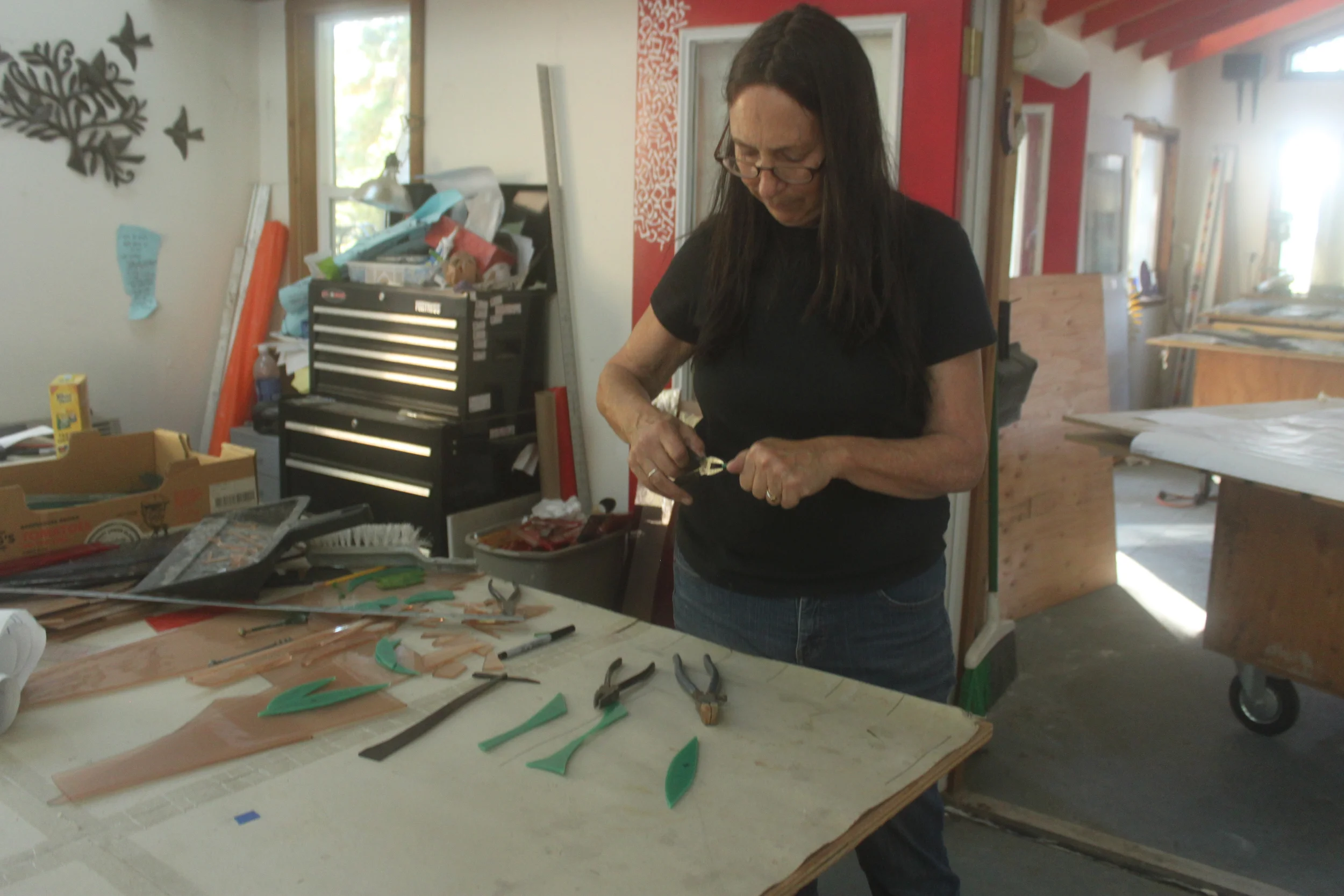  Michelle, in the cutting room, works on cutting the leaves for one of the ark doors. 