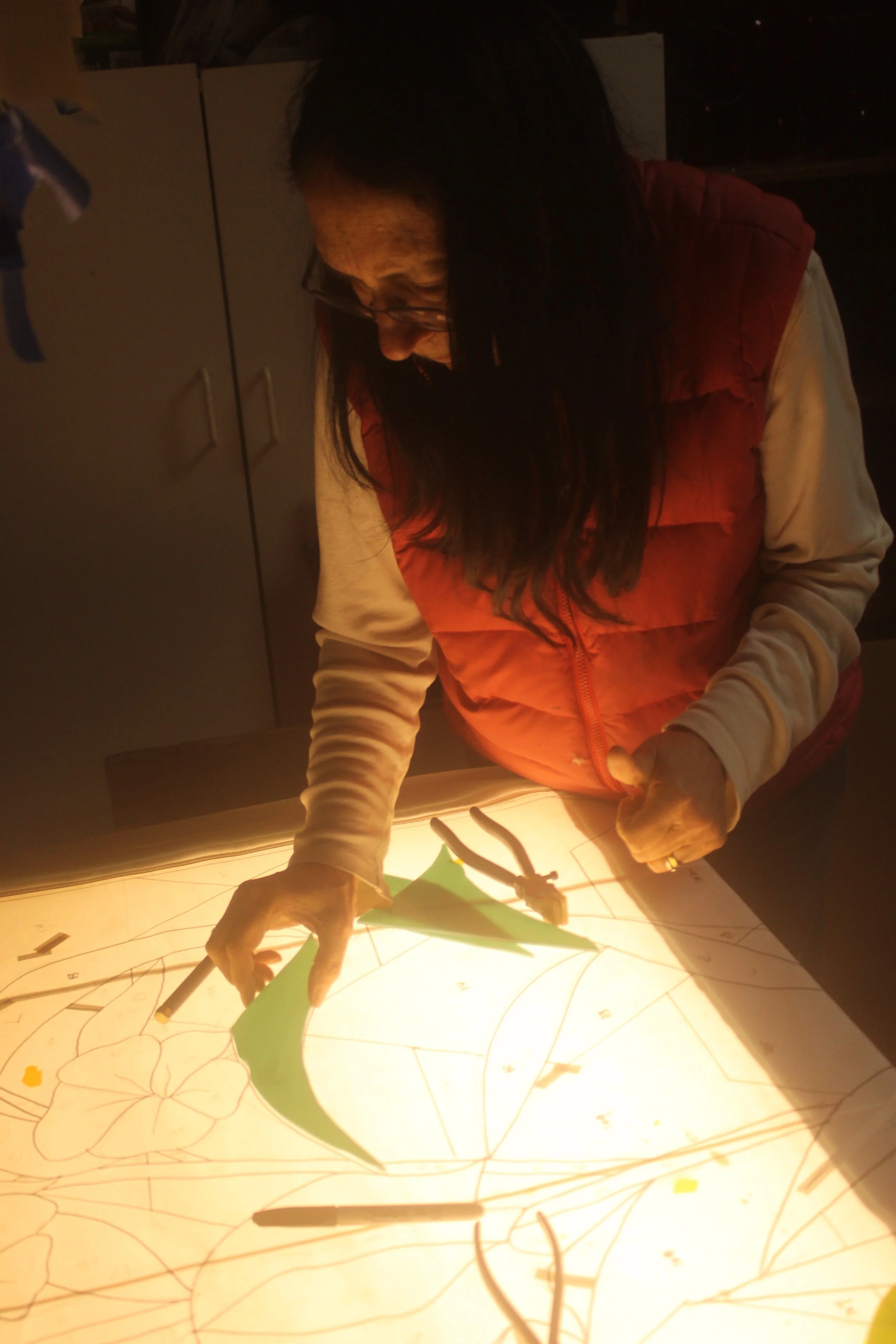 Michelle works on the light table to score the denser colors.