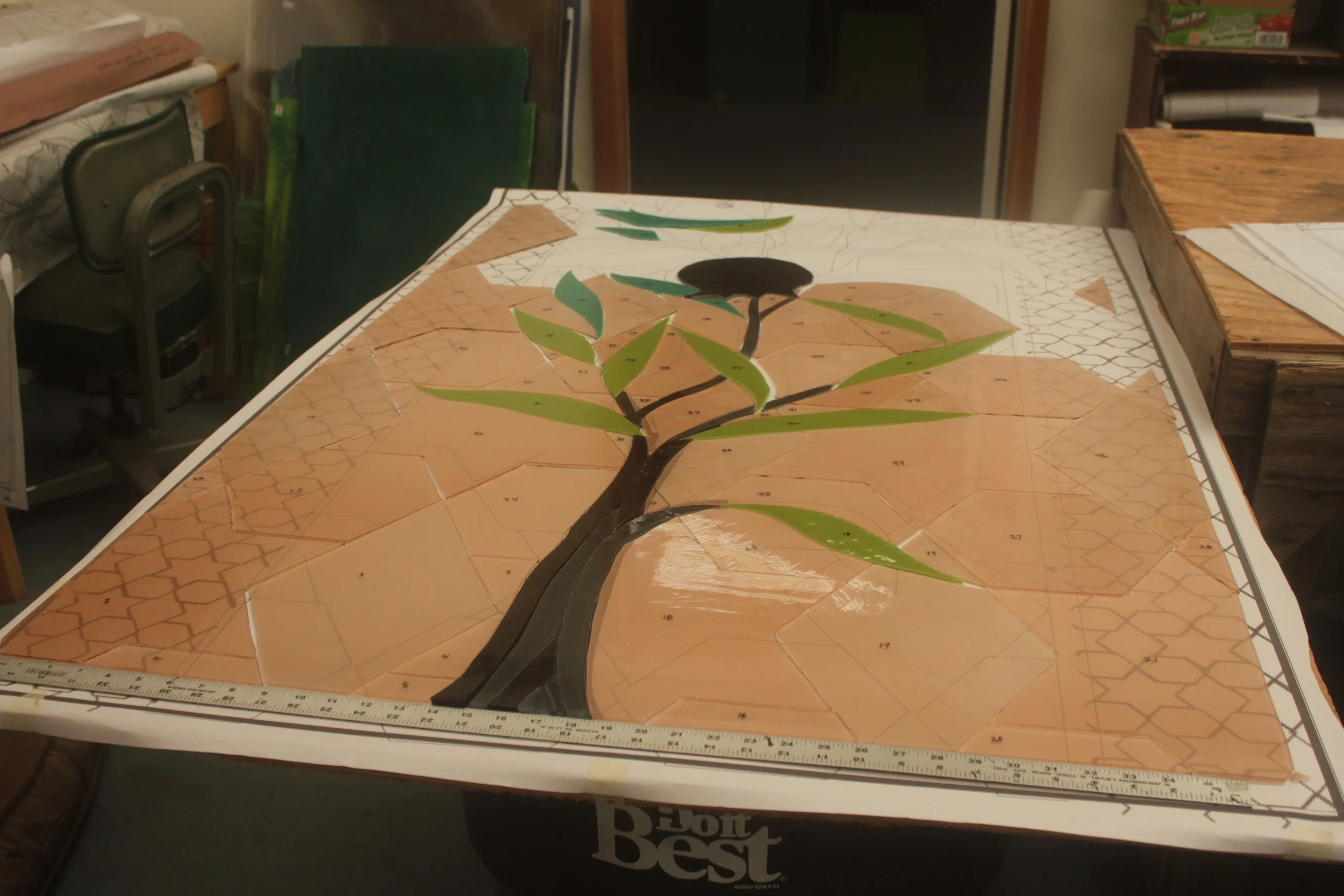 As the pieces of glass are cut, they are each numbered and laid out on a duplicate numbered pattern.