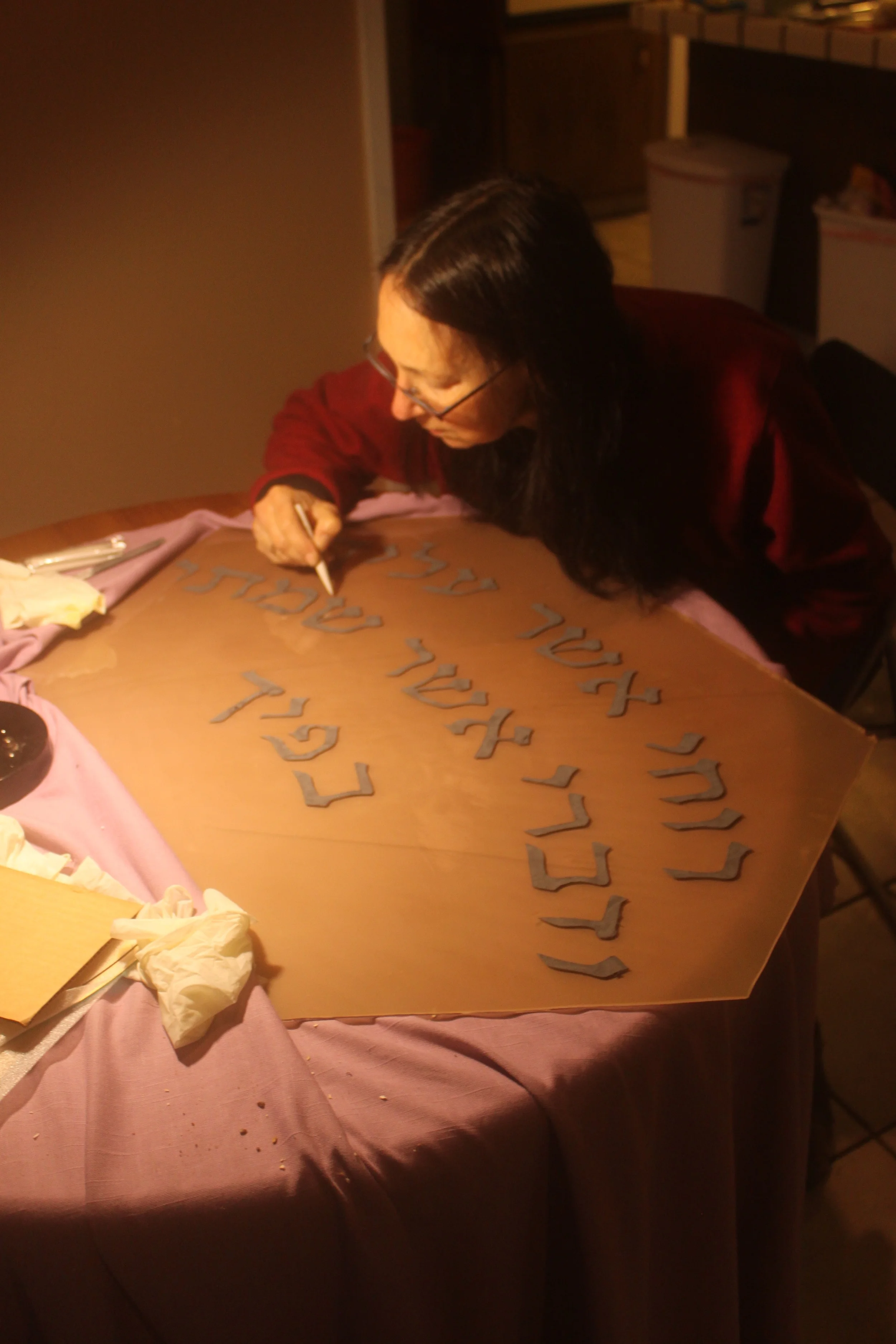 The edges of the painted letters are cleaned with a paper stump.