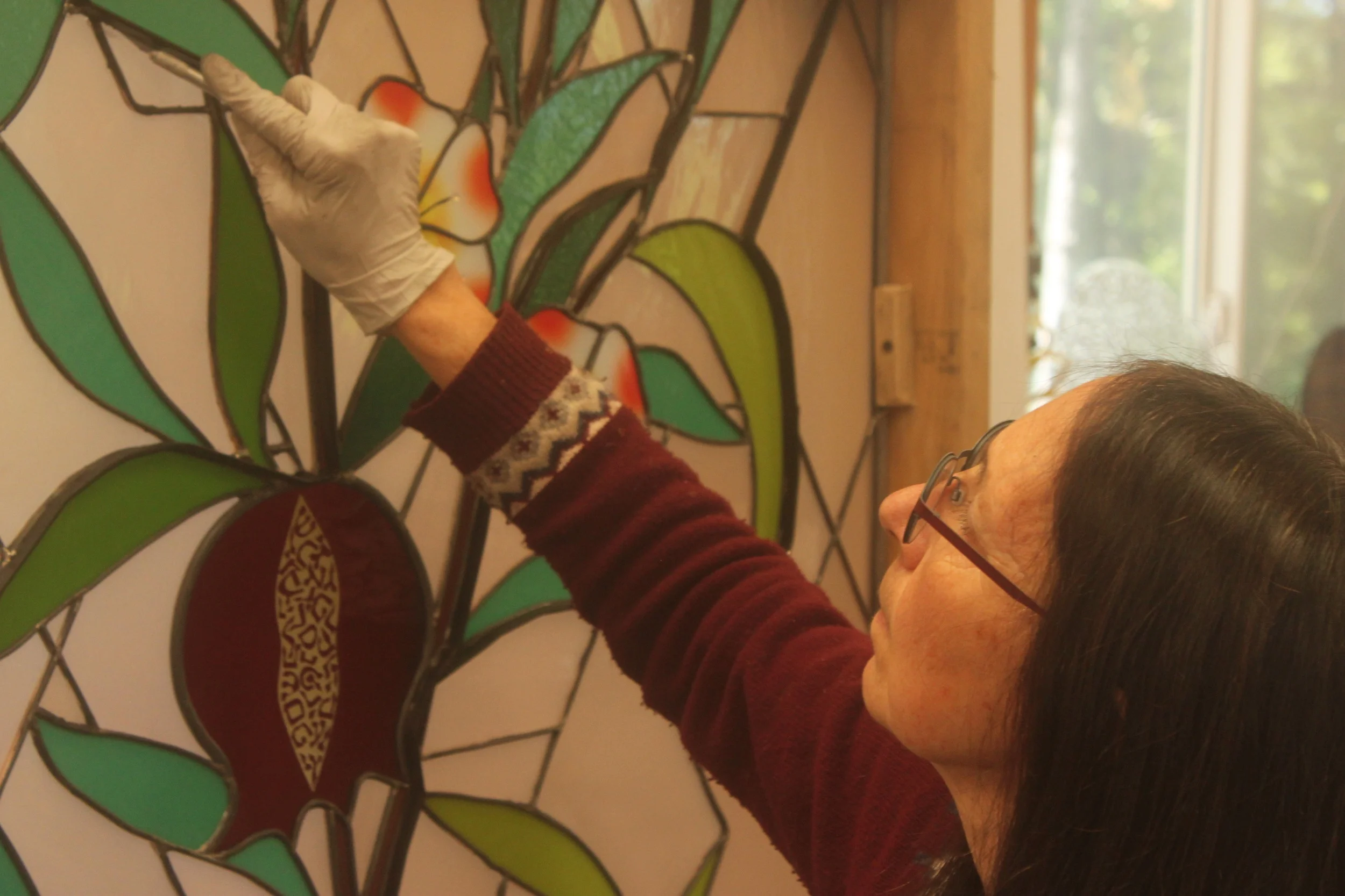 Michelle touches up the glazing on one of the pomegranate panels.