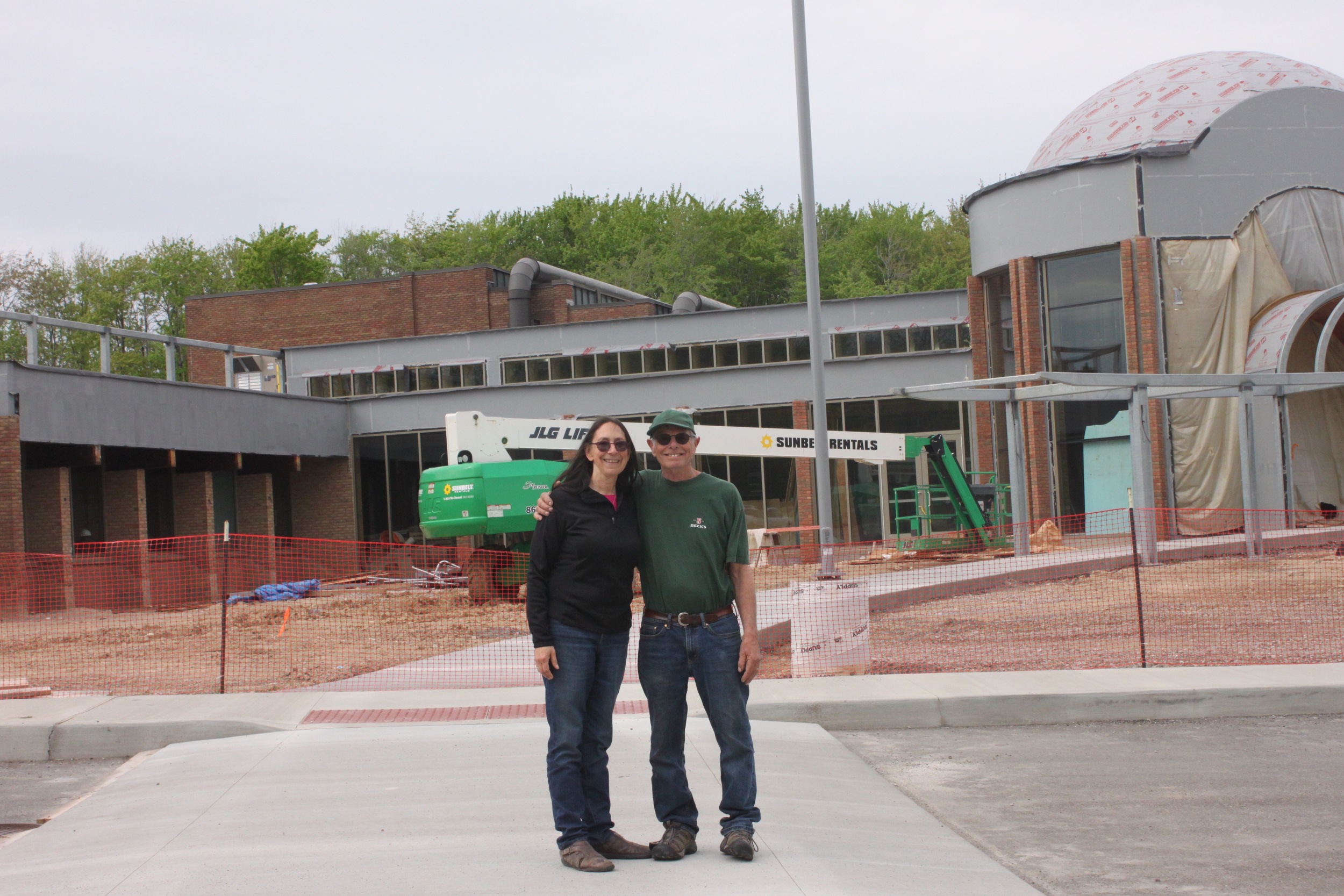 After delivering the glasswork for the new ark doors, David and Michelle pose in front of the new construction at Temple Tifereth Israel.