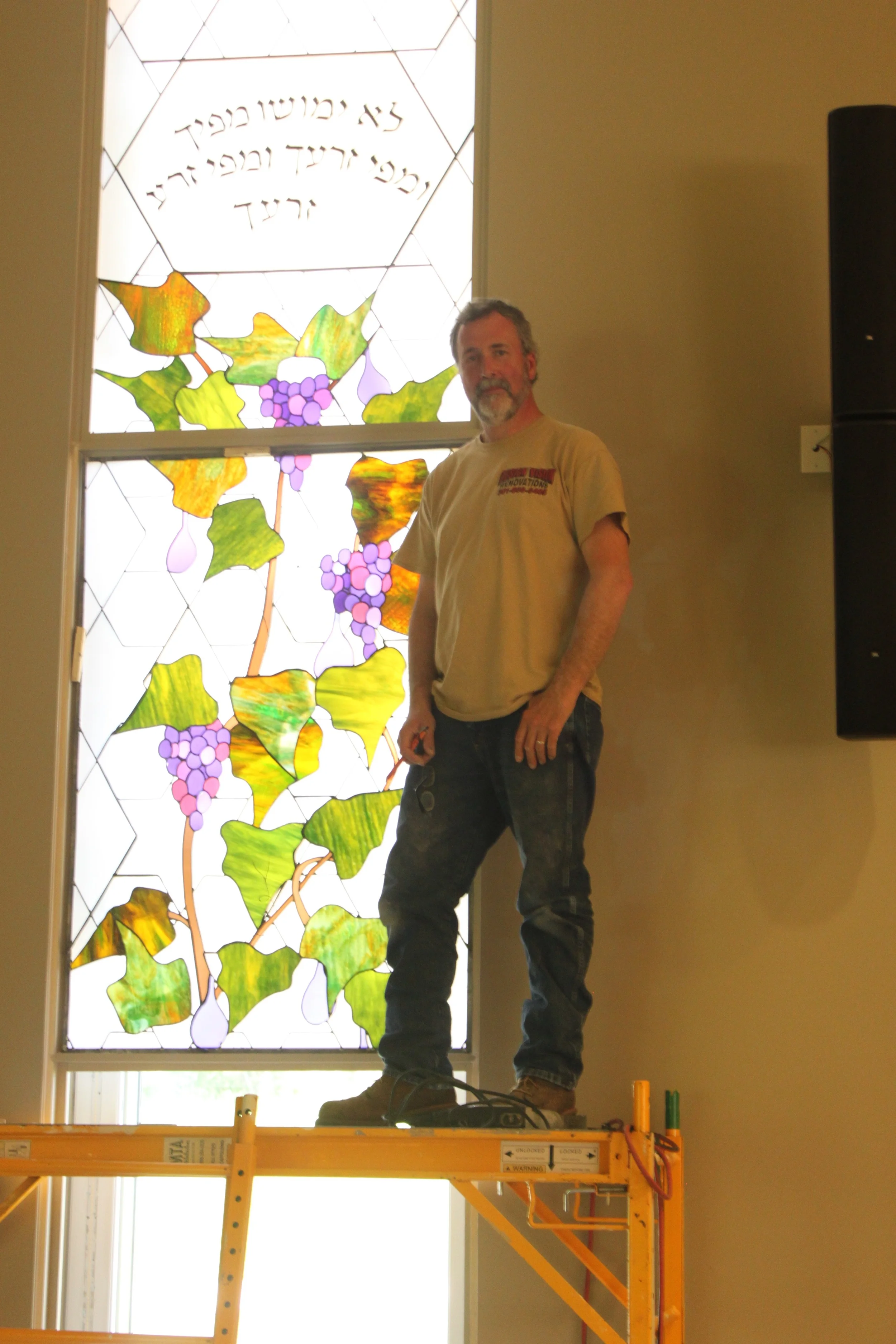 David Rosenburger awaits the stops while installing the second grapevine panel.