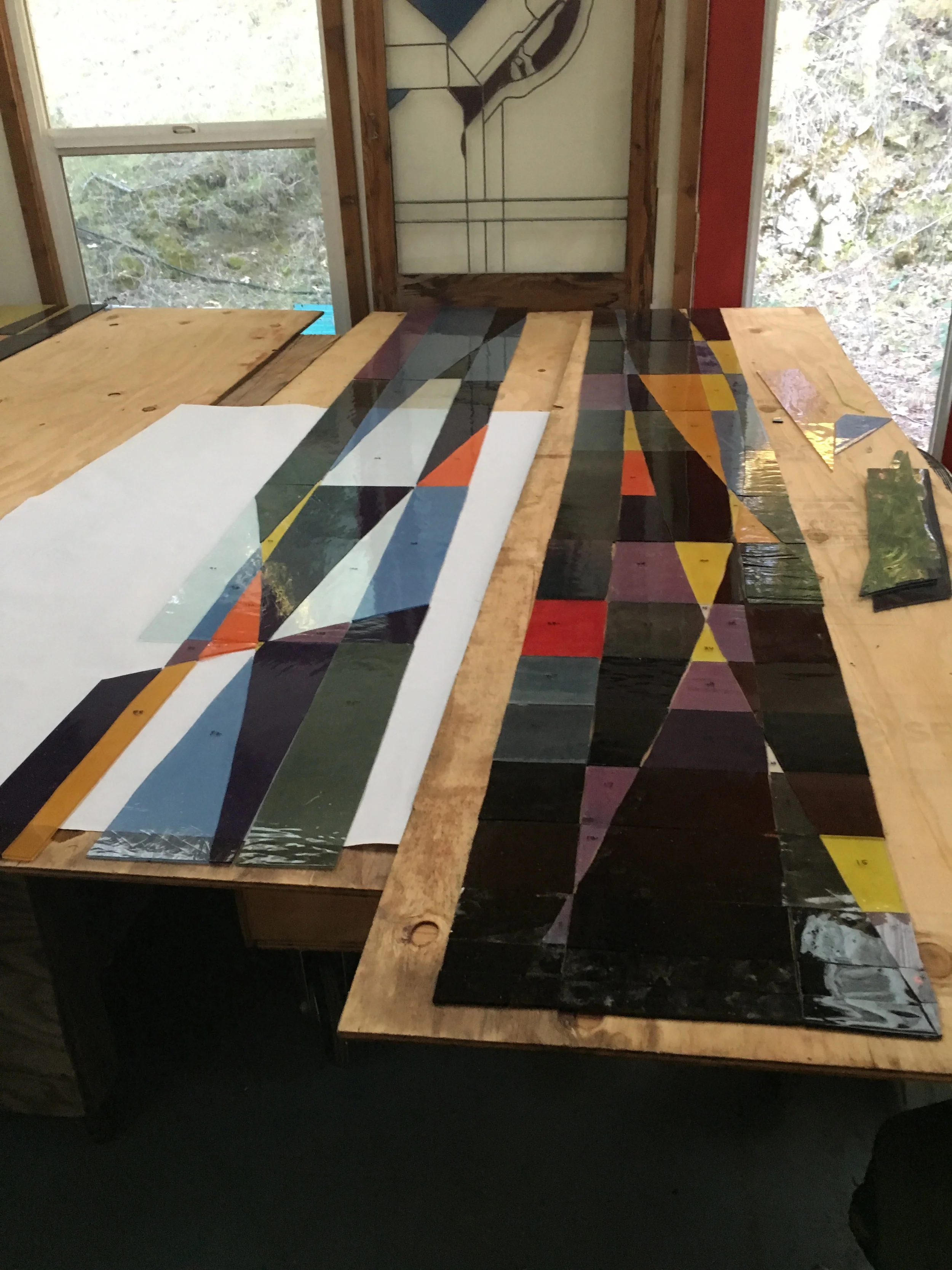 Pieces of window are cut and laid out on a duplicate pattern.