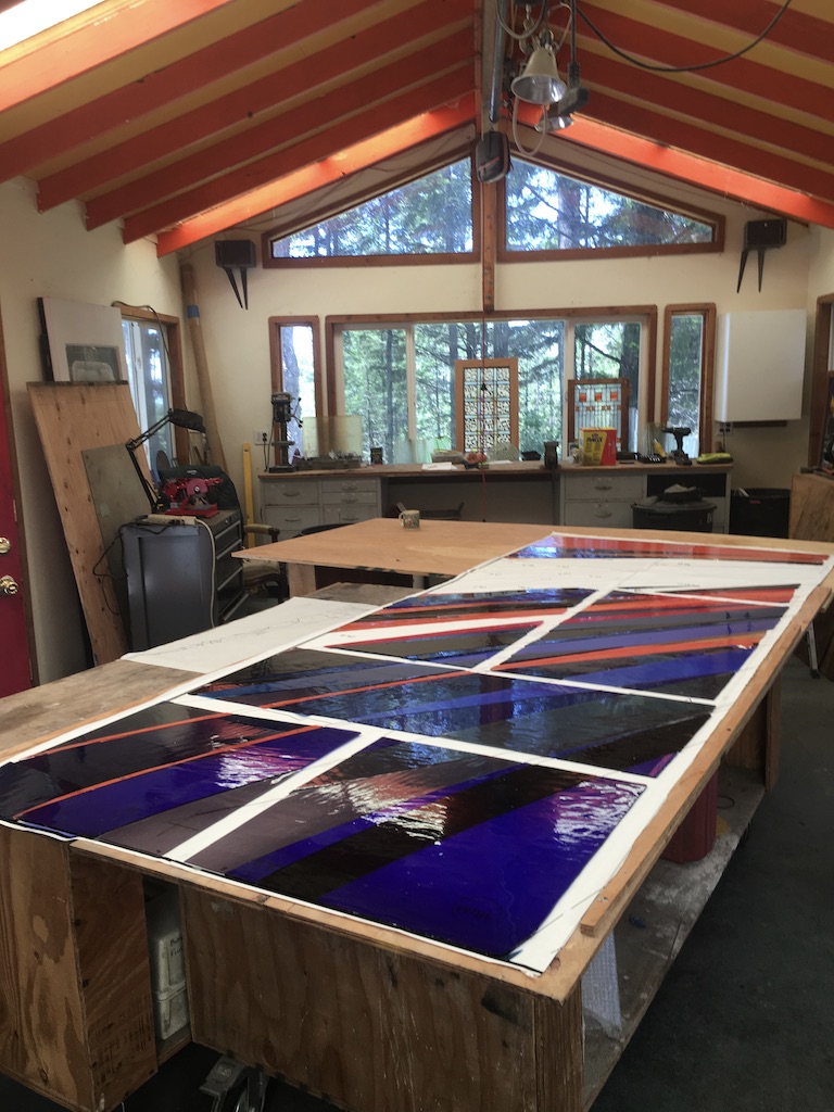 The left door is laid out on a table as Michelle cuts the glass.
