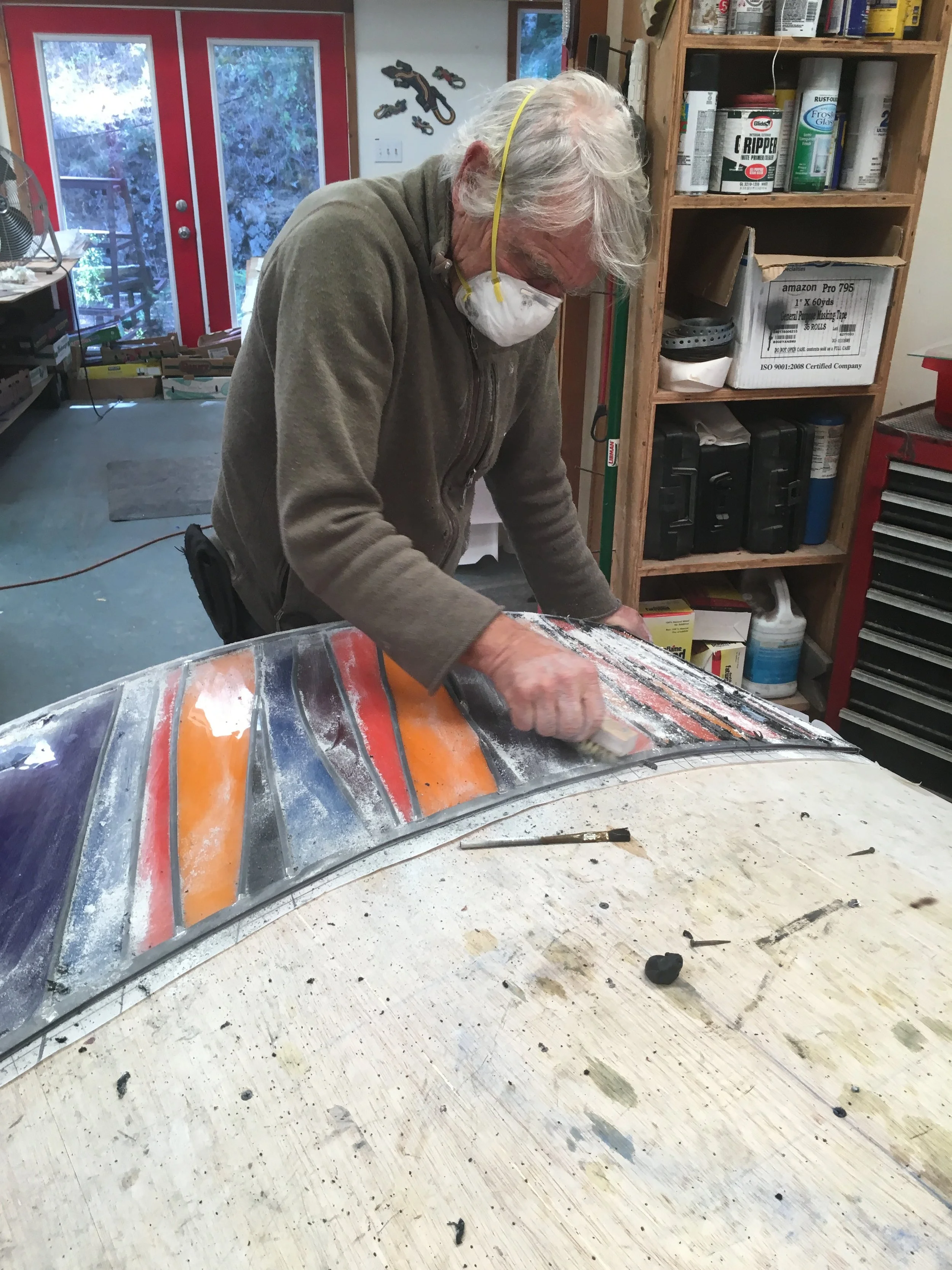  David cleans off the excess putty following the glazing of a panel. 