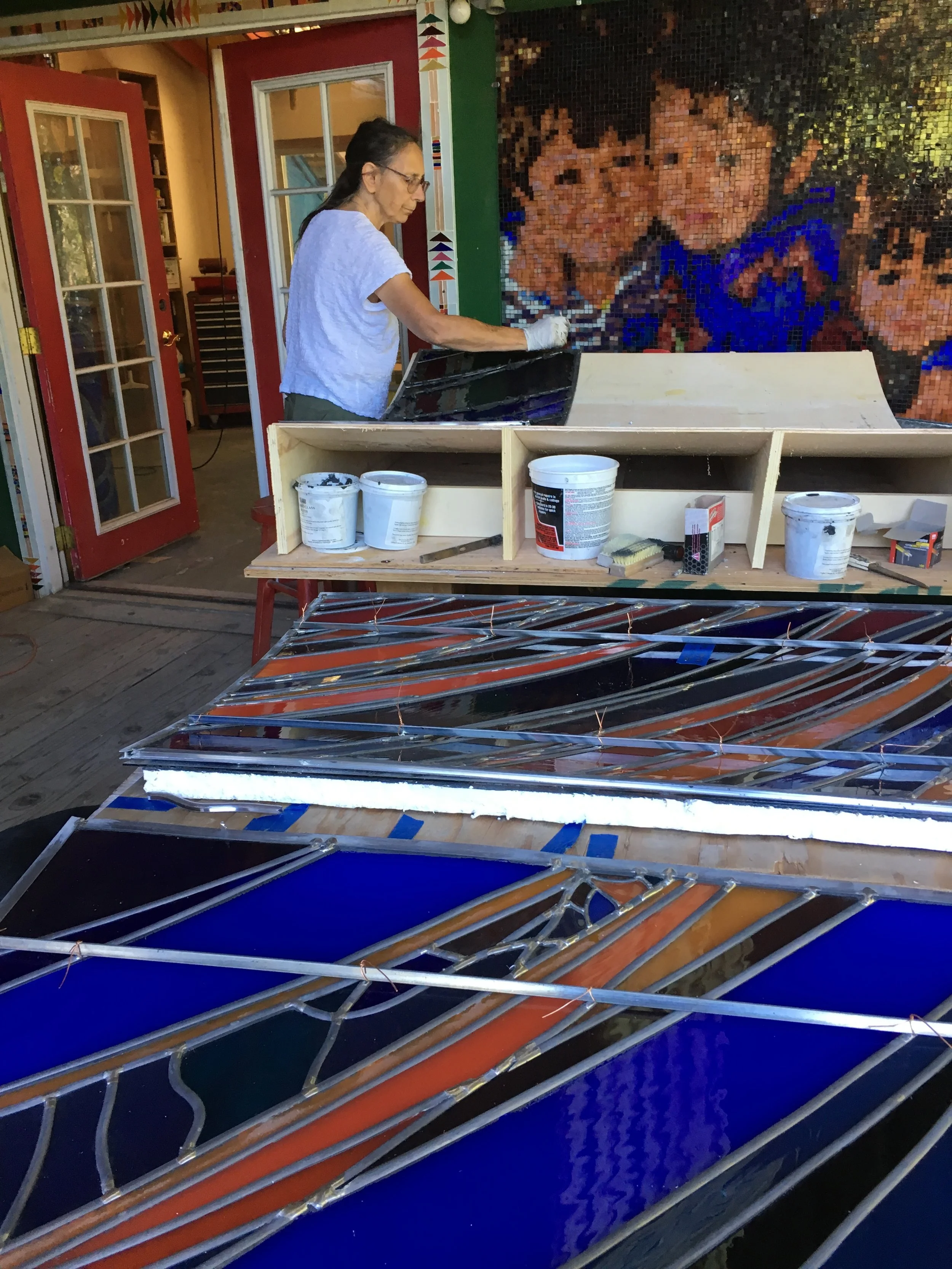  Michelle glazes the backside of a panel. 