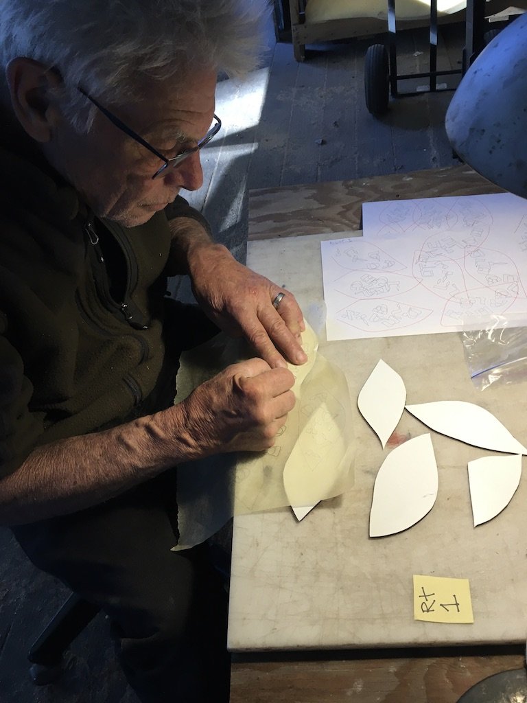 David works on preparing the leaf pieces for painting.