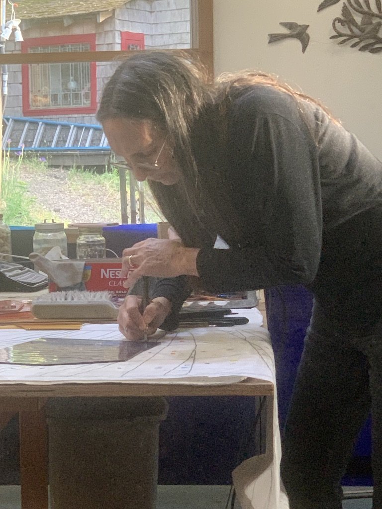 Michelle scores a piece while cutting glass for the ark doors