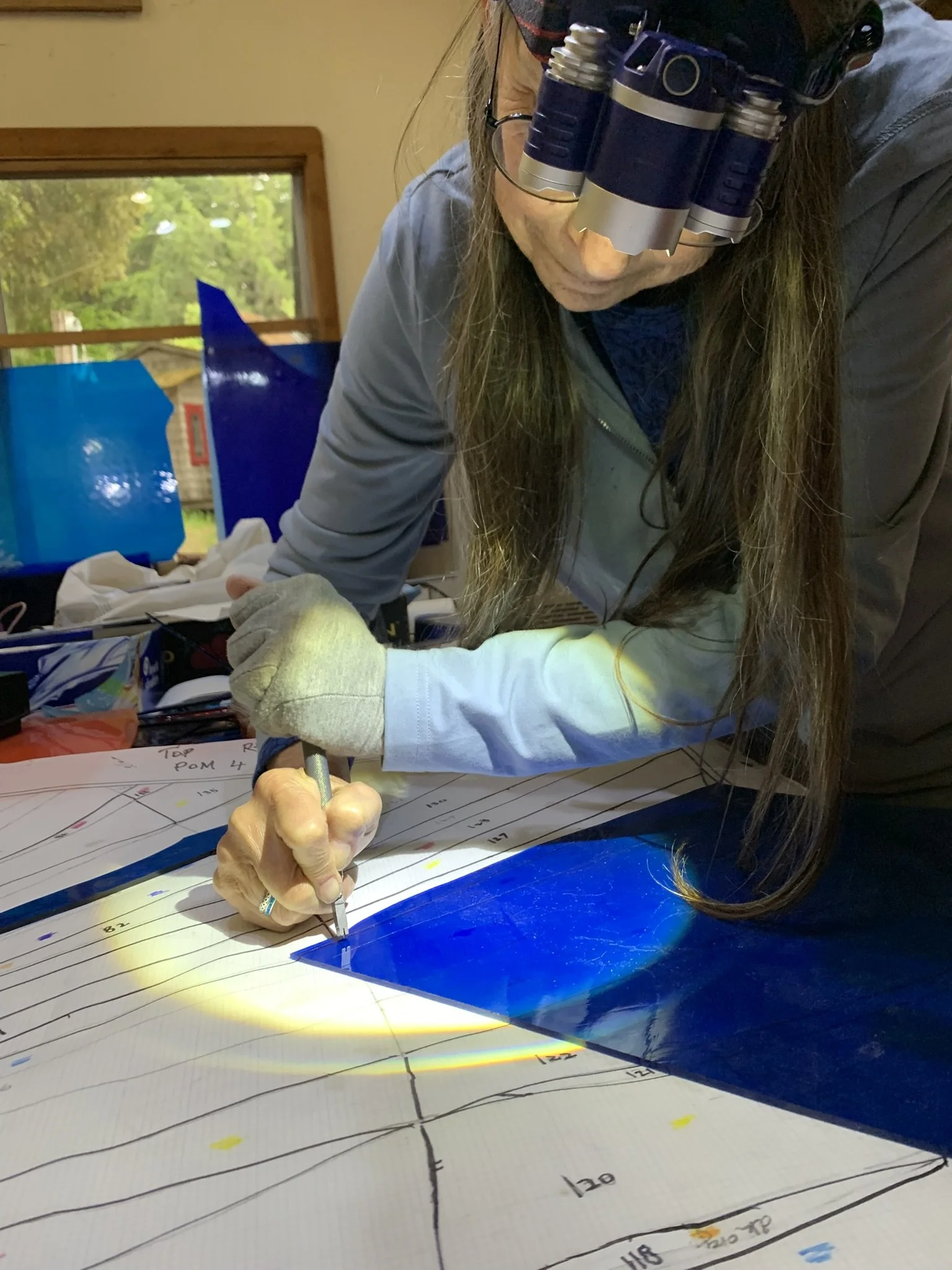 Michelle cuts glass using her headlamp to provide additional light 