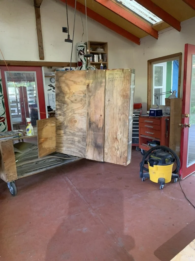  A window hangs from the hoist while being lowered to the floor.  