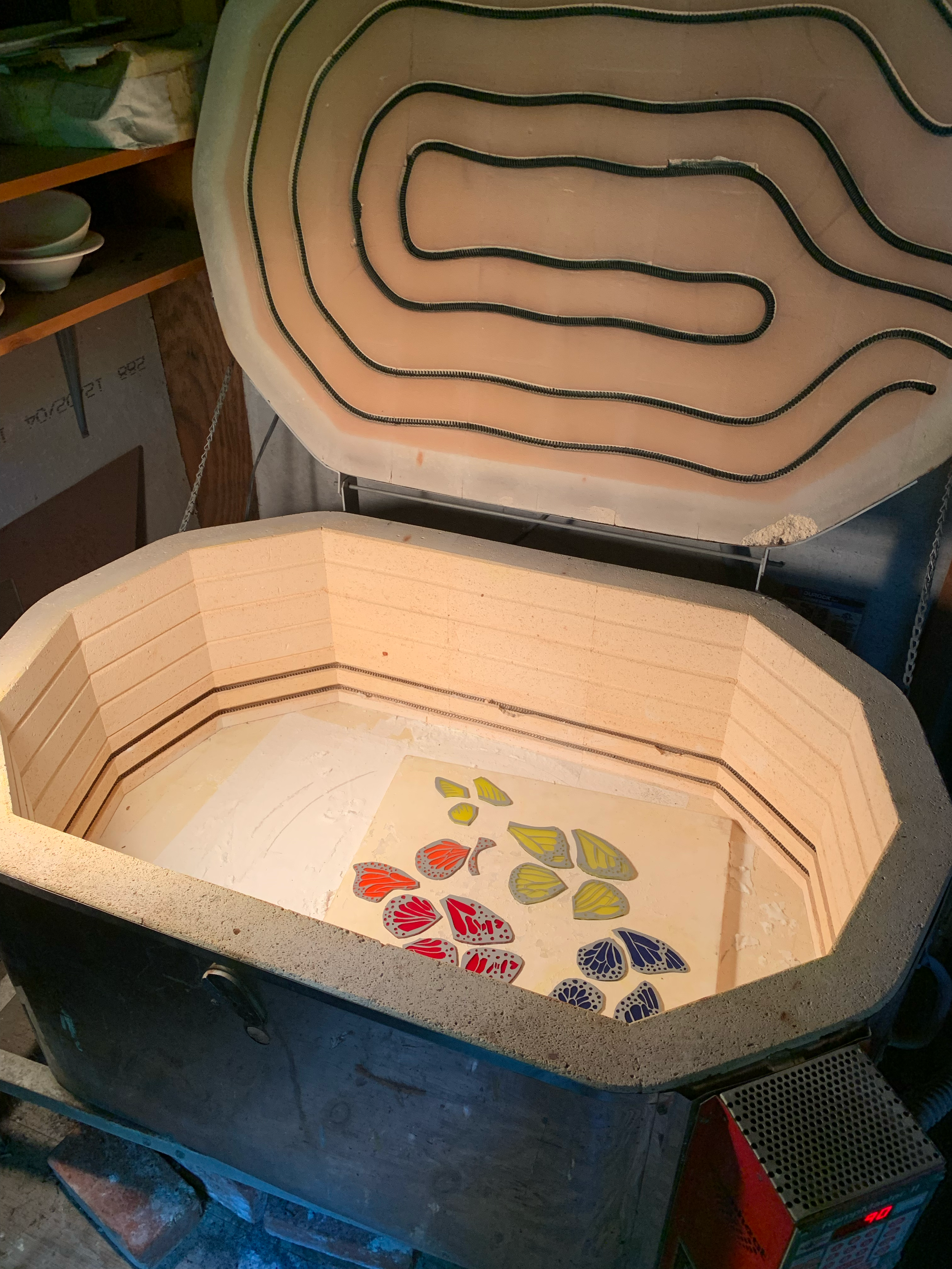     butterfly pieces with resist removed are placed into the kiln ready for firing 