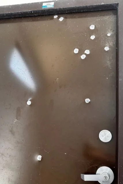 Who was shooting at the bathroom door, and why?