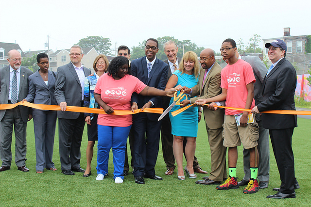 City officials, students, and faculty gather around to cut ribbon.