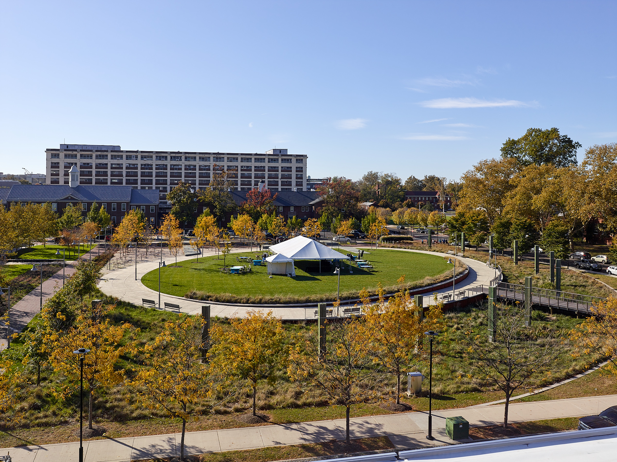 League Island Park at the Navy Yard, Philadelphia, PA League Island Park, proposed for the 2.5 acre parcel between 11th and 12th Streets on Constitution Avenue, will provide another major amenity within the historic district. Physically located above the original League Island in the Delaware River prior to the expansion of the Navy Yard property eastward, the park is intended to celebrate the islands origins. An expansive stormwater collection system designed as a constructed wetland with native grasses will edge the central mounded lawn oval. A footbridge will lead pedestrians from the perimeter walking paths to the “island”. Decorative wood pilings have been incorporated as lighting features and remnants of pier slabs will provide opportunities for seating. Recycled shells from the Delaware River will be ground and utilized as a soft paving material.