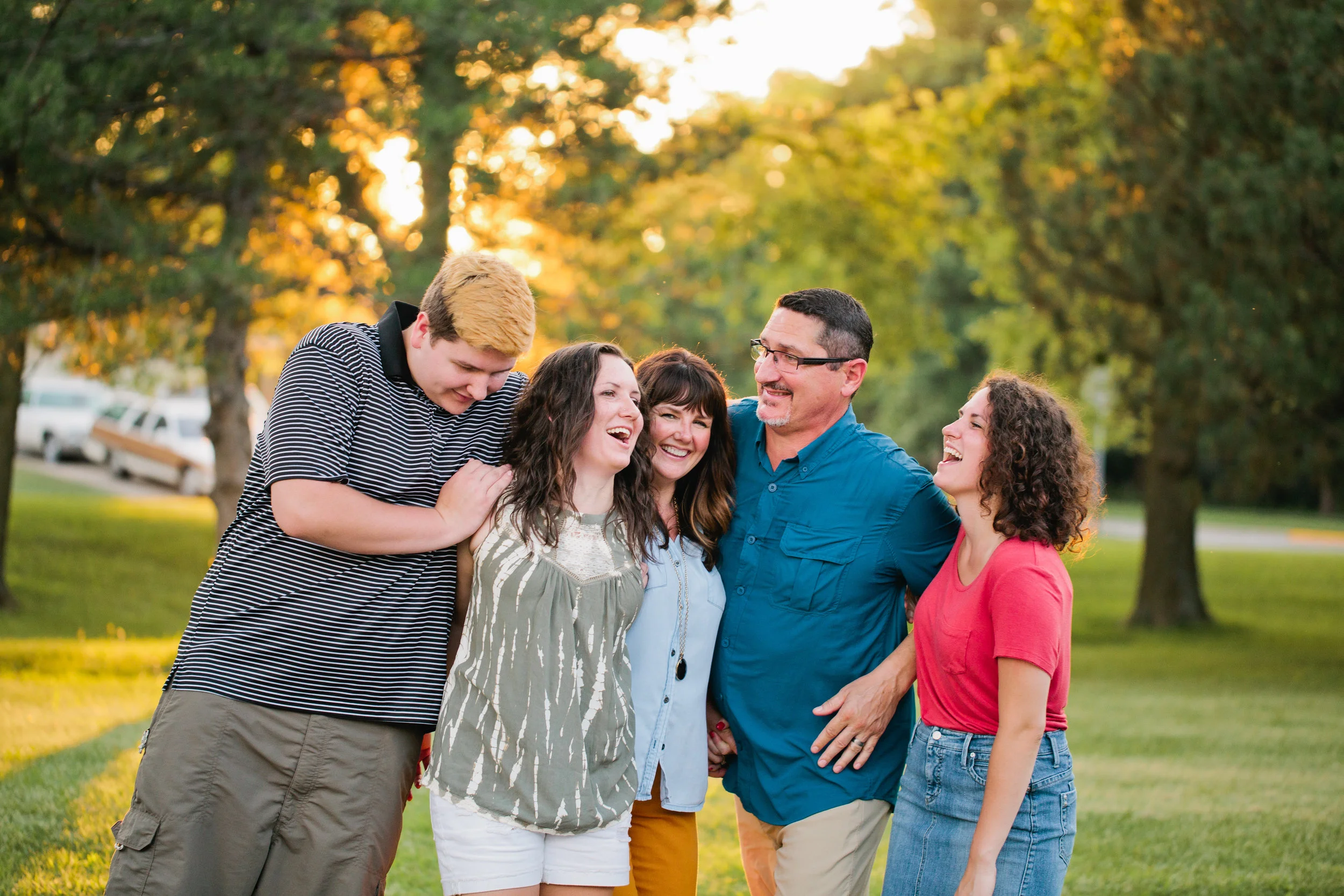 family laughing in park at sunset during family photography Des Moines parks Iowa