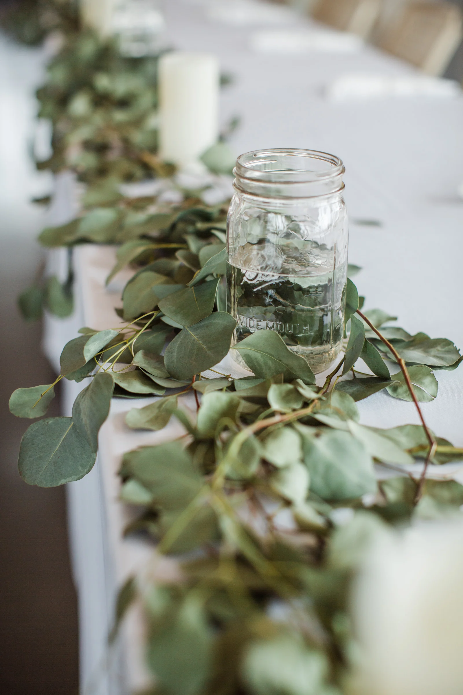 mason jars and eucalyptus on head table wedding reception
