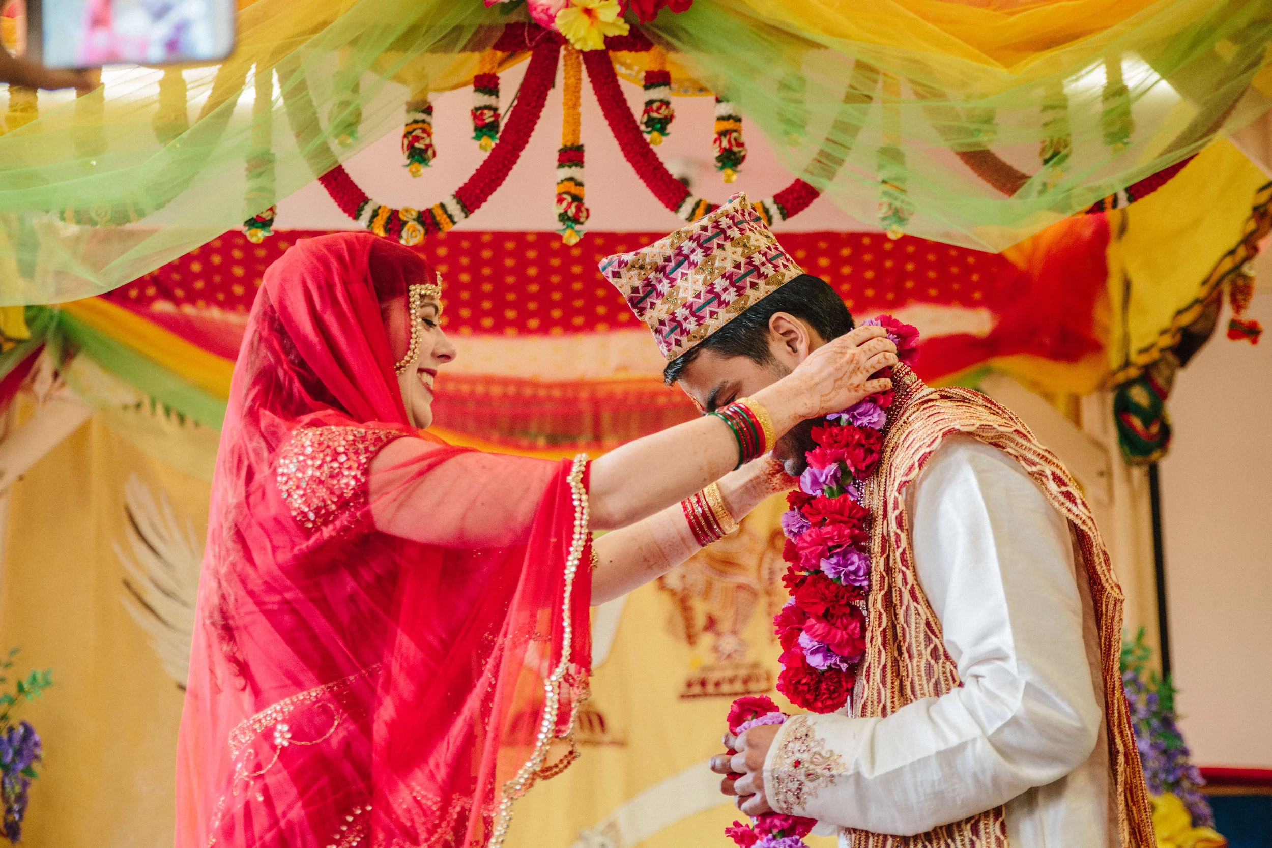 bride and groom exchange flower garlands during wedding ceremony