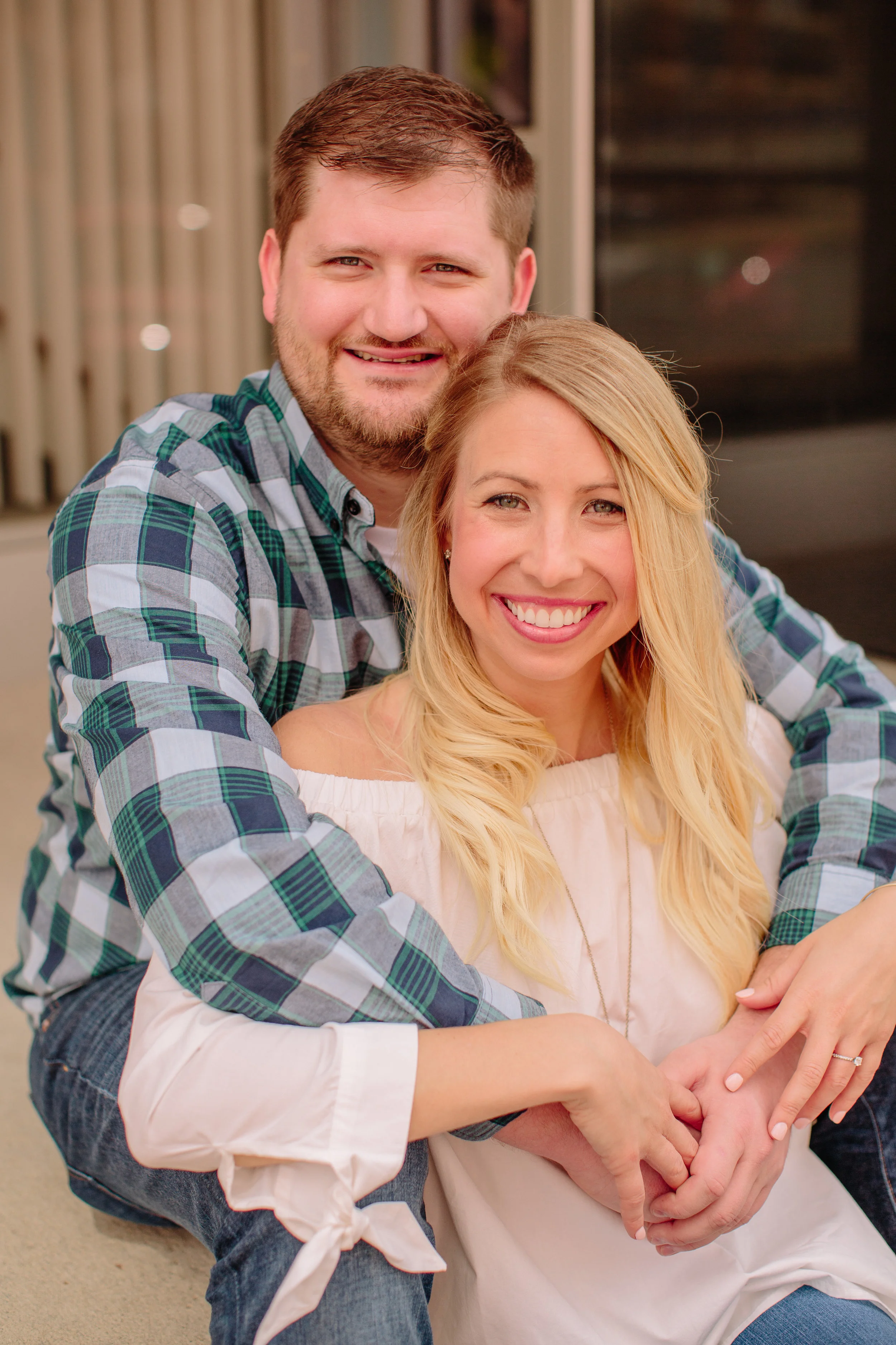 Des Moines downtown engagement photos couple sitting and cuddling on steps