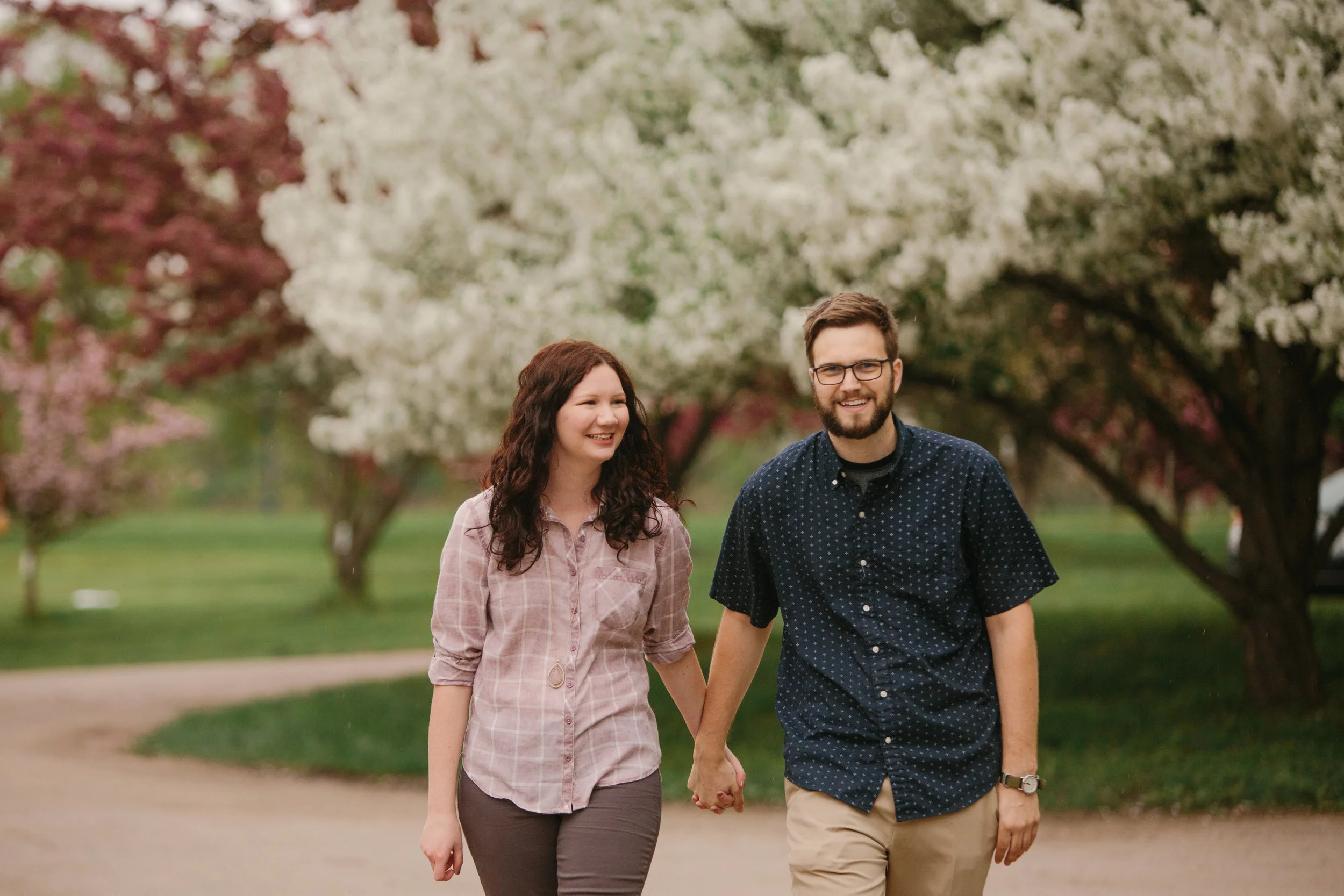 couple walking and smiling engagement photos iowa des moines cedar falls