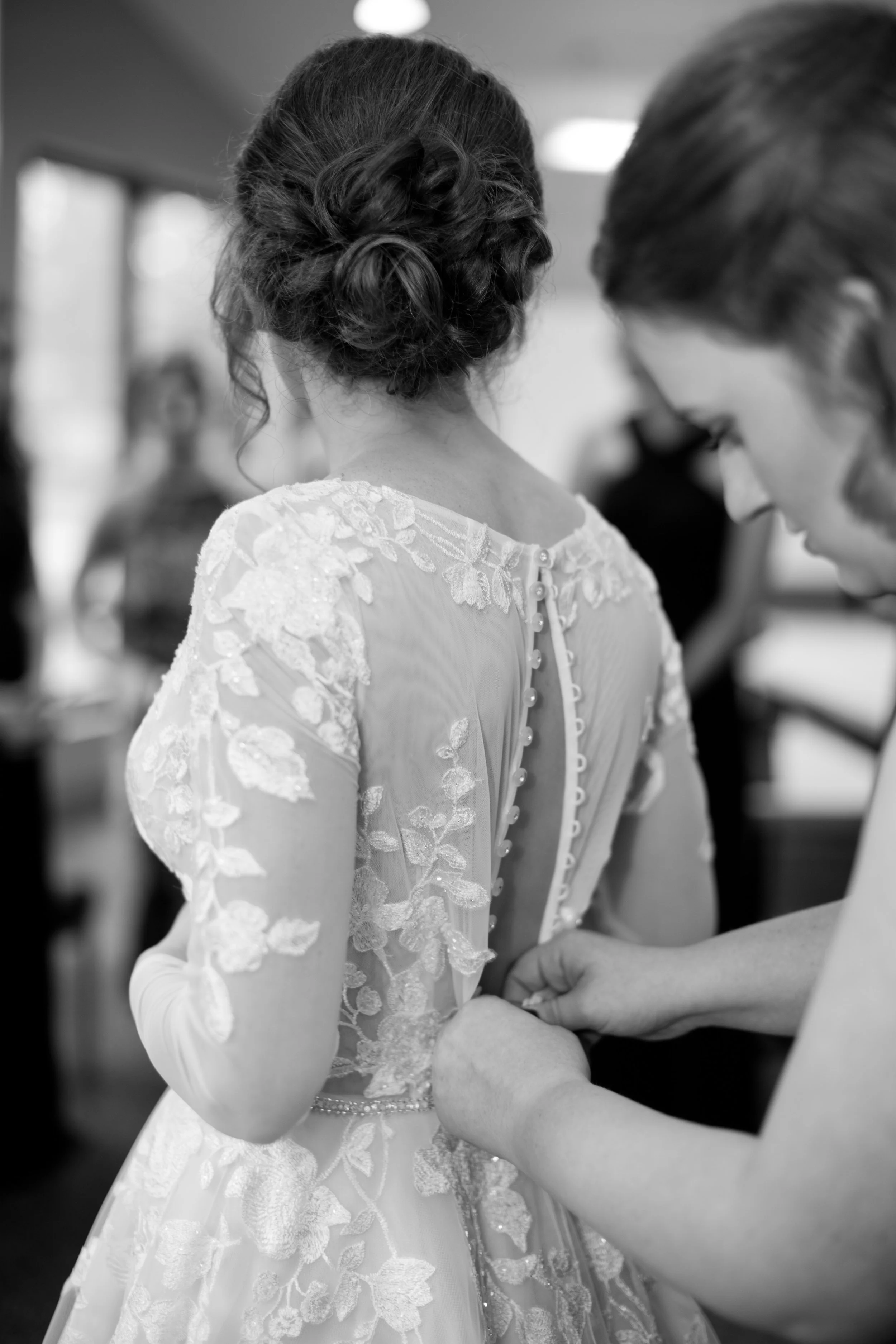 bride buttoning her wedding dress with sister // Osceola wedding photographer amelia renee