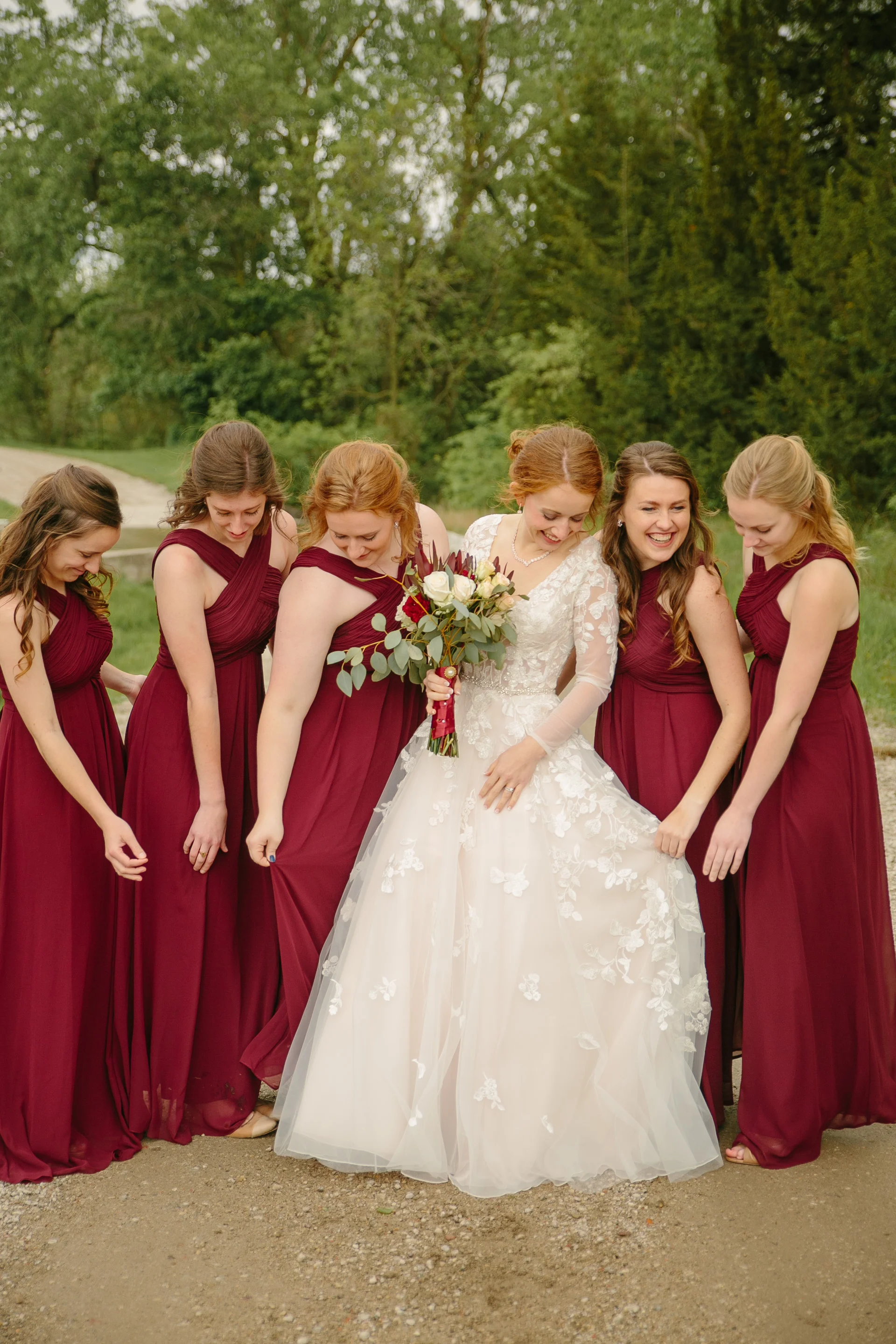 bride and bridesmaids in burgundy wine dresses at outdoor weddin in des moines