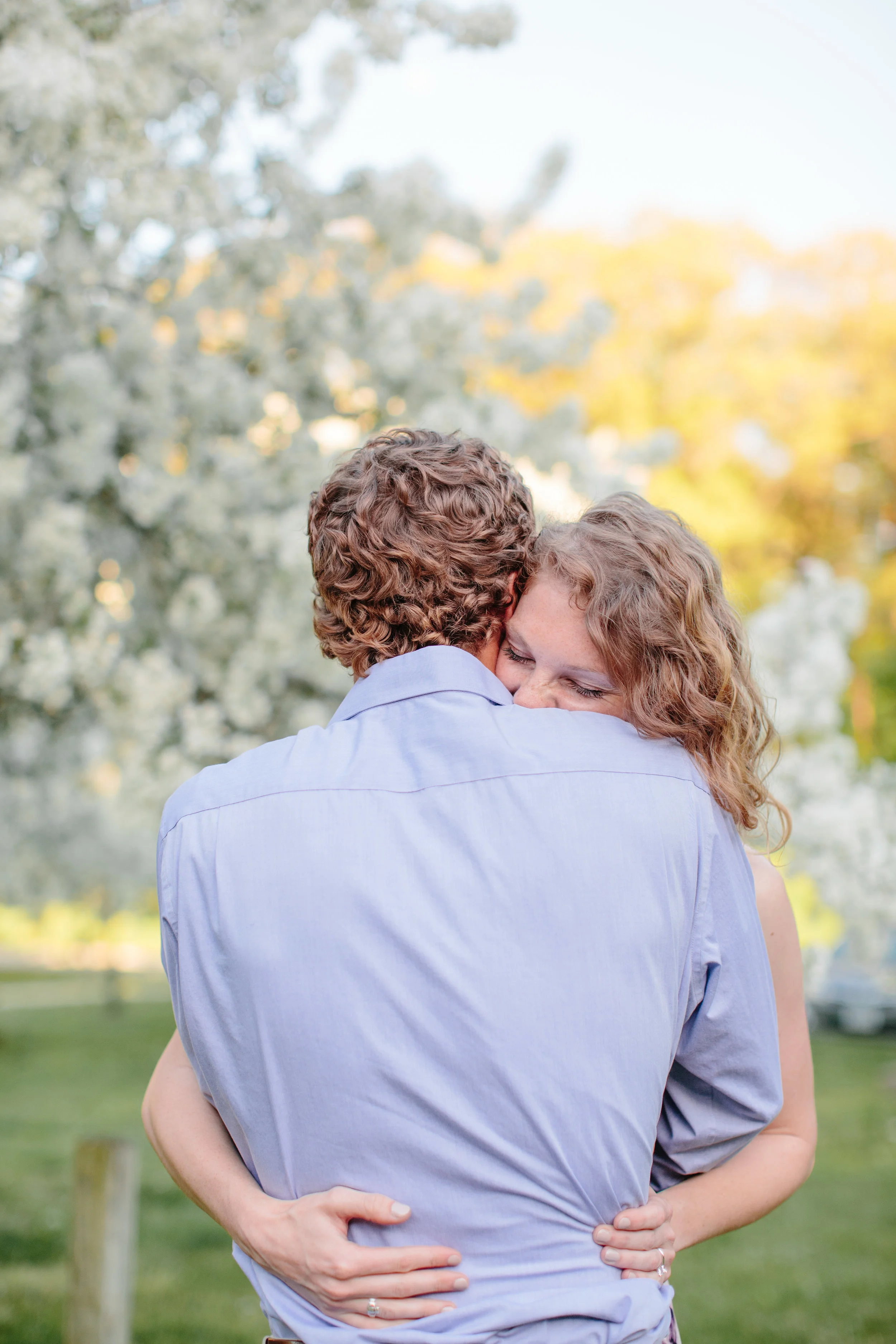 fiance hugging her groom to be in park