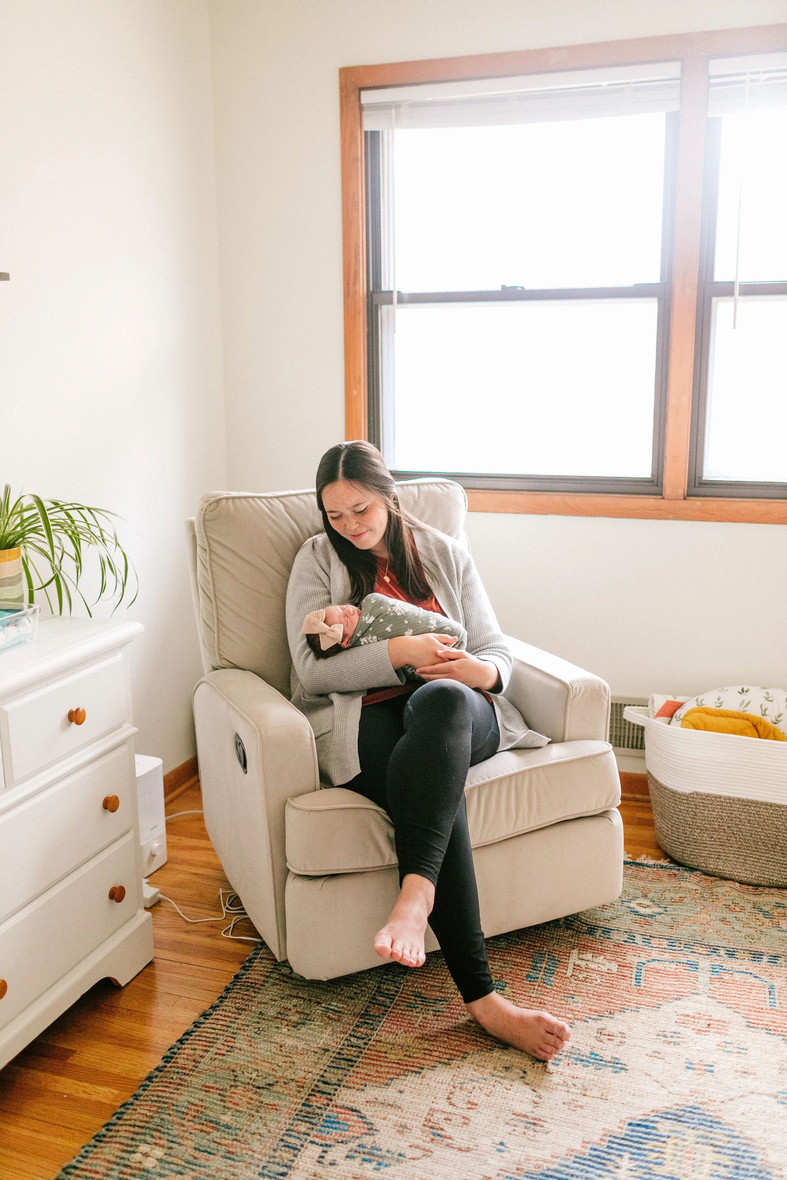 mom rocking baby in nursery omaha newborn photos