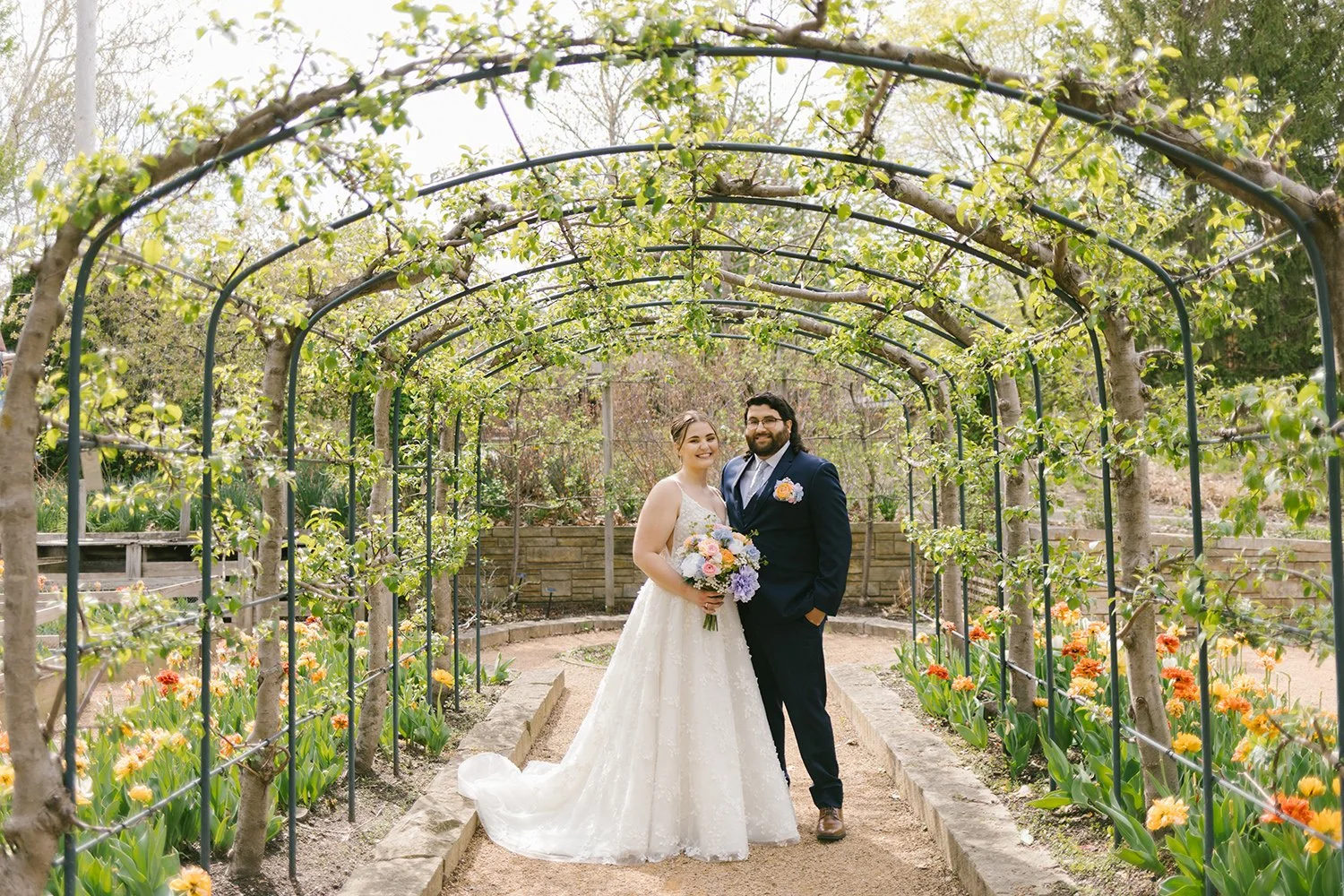couple standing under floral arch with tulips wedding