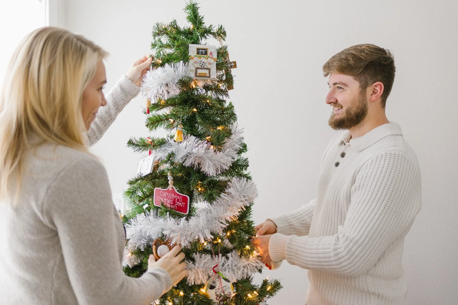 couple decorating tree in brand new home christmas session